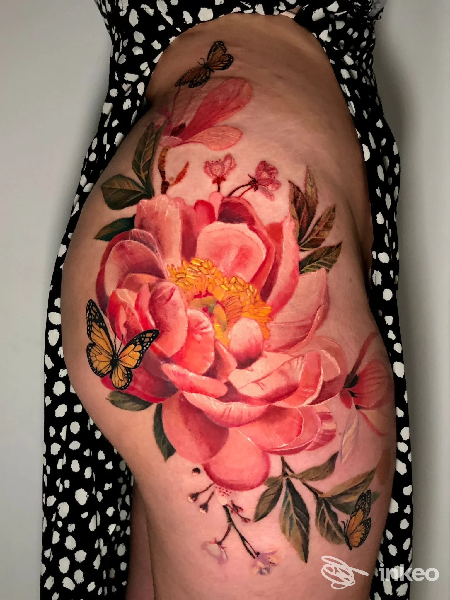 Grande tatuaggio floreale rosa su fianco e coscia, eseguito da Alex de Pase Tattoo&Piercing Store a Trieste.