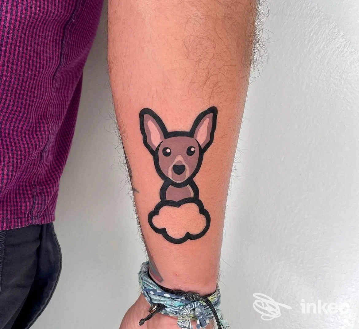Tatuaggio stilizzato di un cane su avambraccio realizzato da Green Tattoo & ArtLab a Sacile, su pelle chiara con contorno nero spesso.