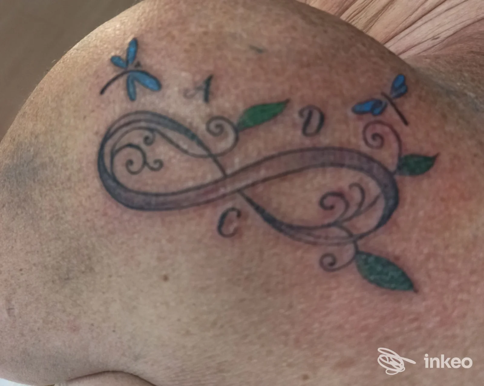 Tatuaggio a forma di infinito con decorazioni floreali e farfalle sulla spalla, foto fornita da Soul Ink Tattoo a Cividale del Friuli.