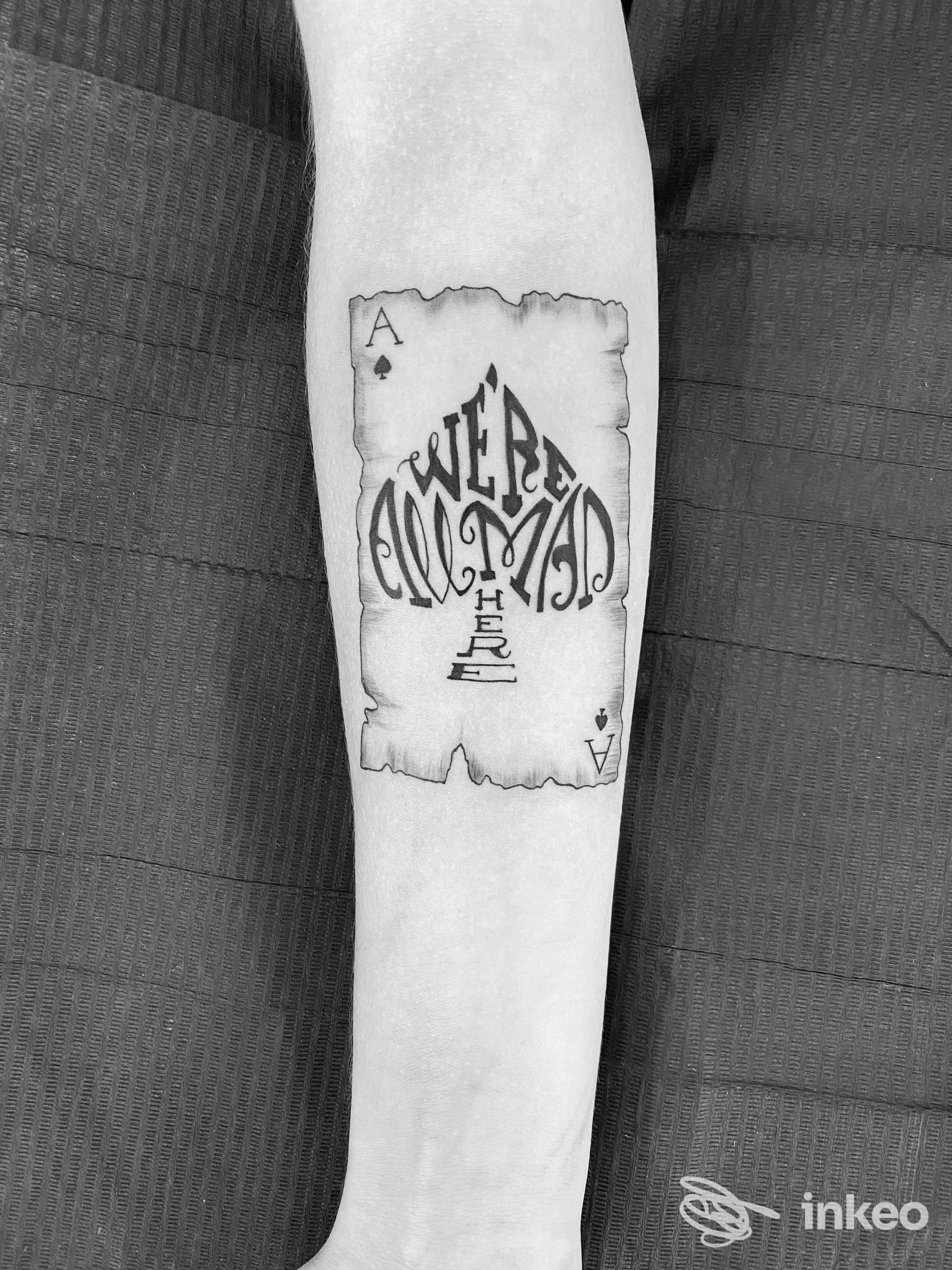 Tatuaggio a forma di carta (asso di picche) con lettering stilizzato sull'avambraccio, Think Ink Tattoo, Palmanova.