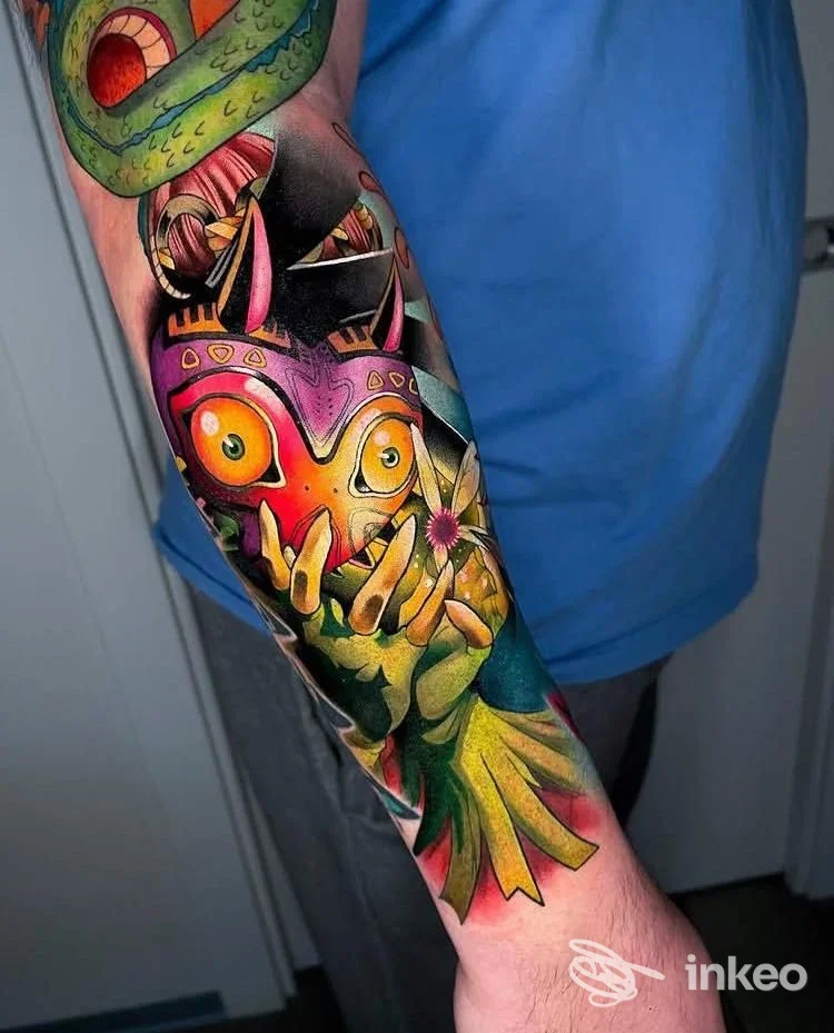 Manica colorata sull'avambraccio con una maschera vivace, mani e fiori in stile illustrativo, fotografia del tatuaggio realizzato da TattooLAB Pordenone, Pordenone.