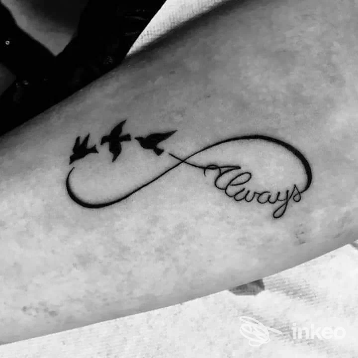 Tatuaggio in nero sull'avambraccio con simbolo dell'infinito, tre rondini e la parola 'always'. Jolie, Tolmezzo.