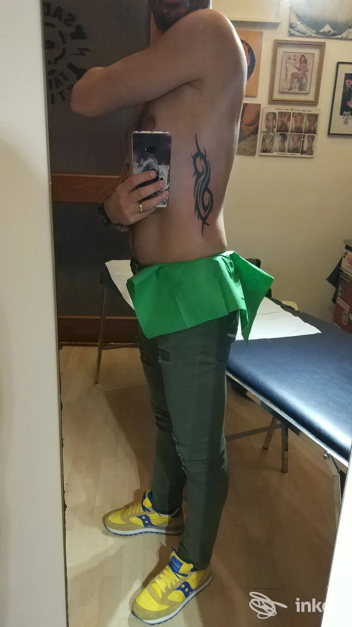 Selfie in studio che mostra un tatuaggio tribale sul fianco; Sadico Tattoo Studio, Pordenone.