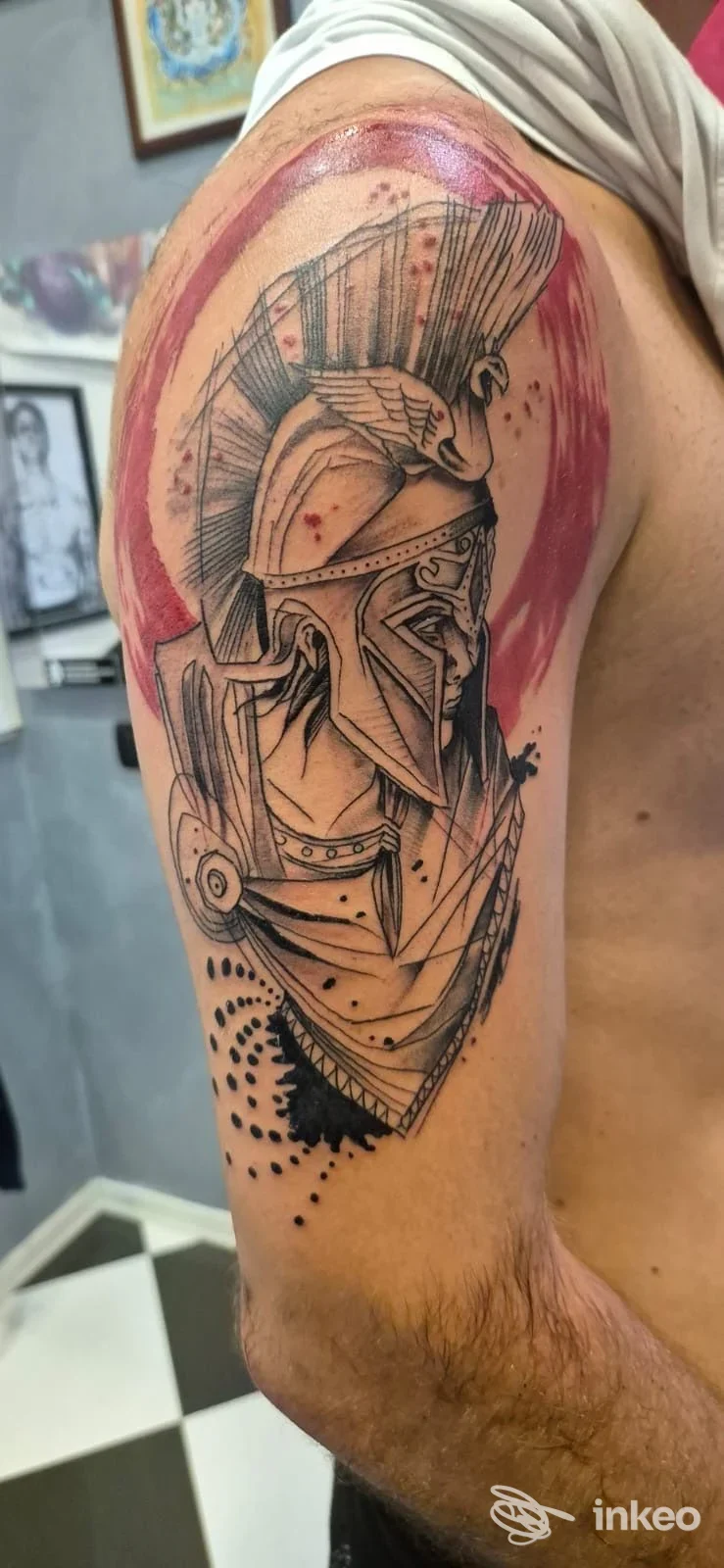 Grande tatuaggio a elmo spartano su spalla e parte superiore del braccio, lavoro di Leonardo Tatuaggi a Trieste.