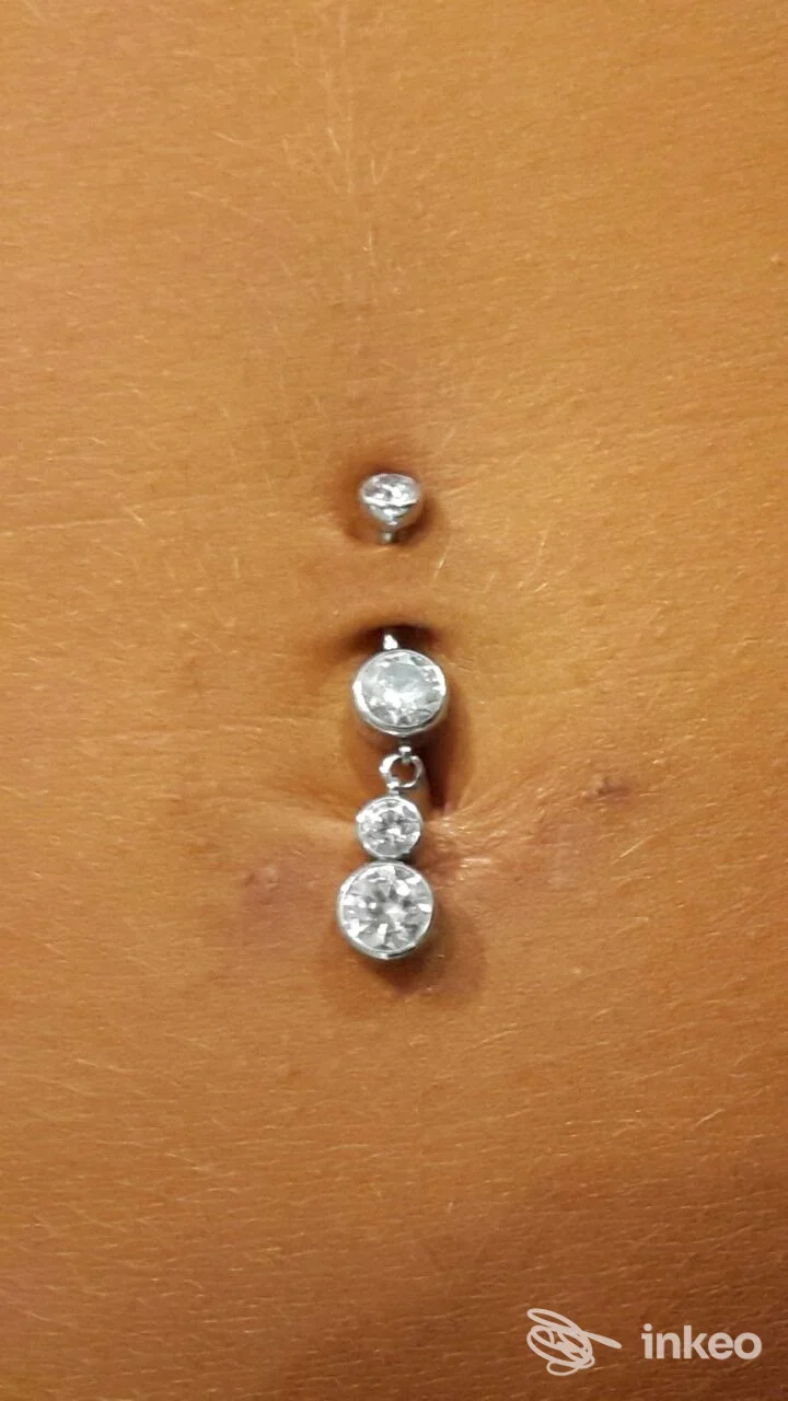 Primo piano di ombelico con piercing gioiello a tre pendenti, foto inviata da Body Factory, Trieste.