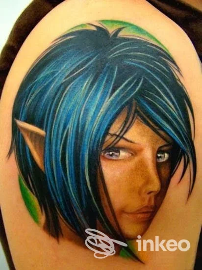 Tatuaggio realistico di un volto fantasy con capelli blu sulla parte superiore del braccio, Ricky Tattoo, Monfalcone.