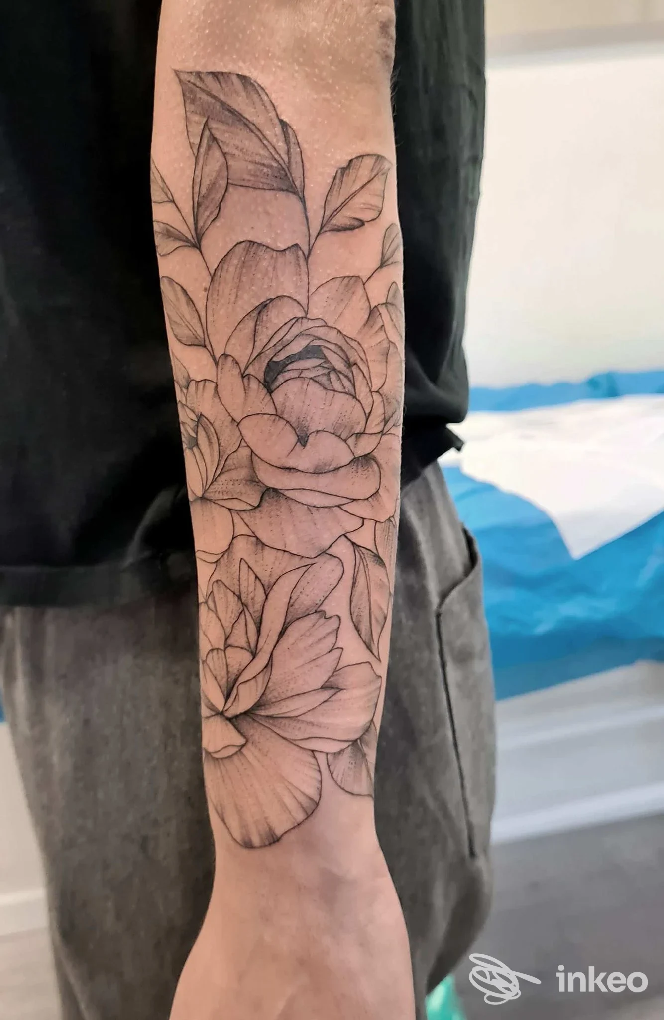 Tatuaggio floreale in bianco e nero sull'avambraccio, foto condivisa dallo studio DOMINO EFFECT TATTOO ad Aviano.