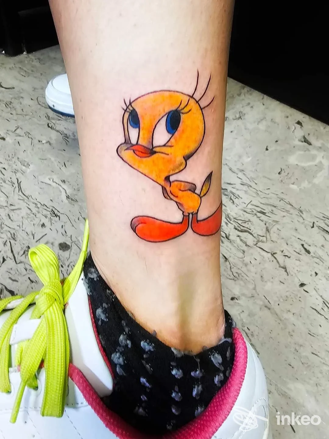 Tatuaggio a colori di personaggio cartone sulla caviglia, foto nitida eseguita presso The Omen Ink-addict a Roveredo in Piano.