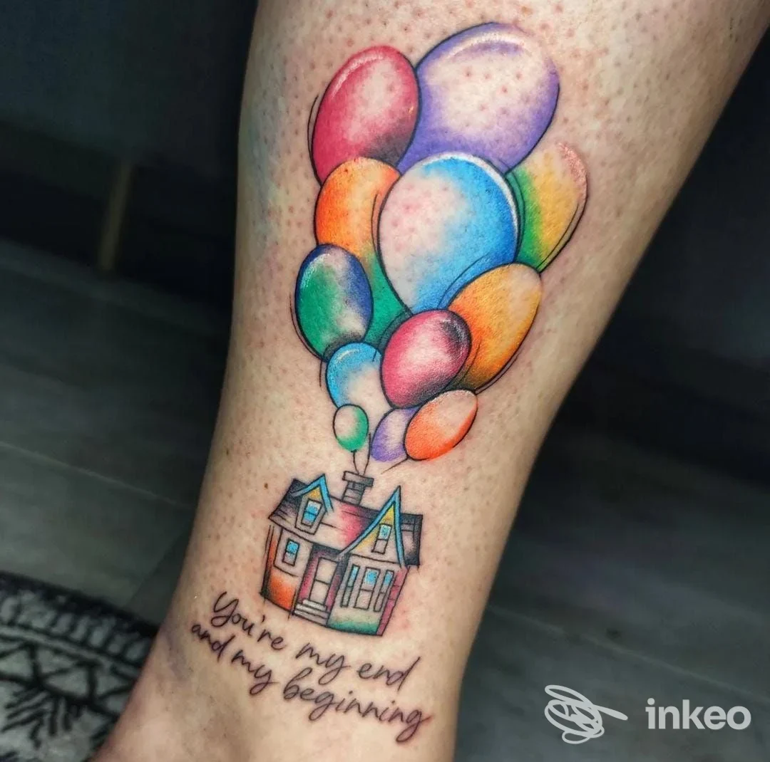 Tattoo visibile su pelle raffigurante una casa con palloncini colorati, accompagnato da una frase scritta a mano. Studio Disinkanto Tattoo.
