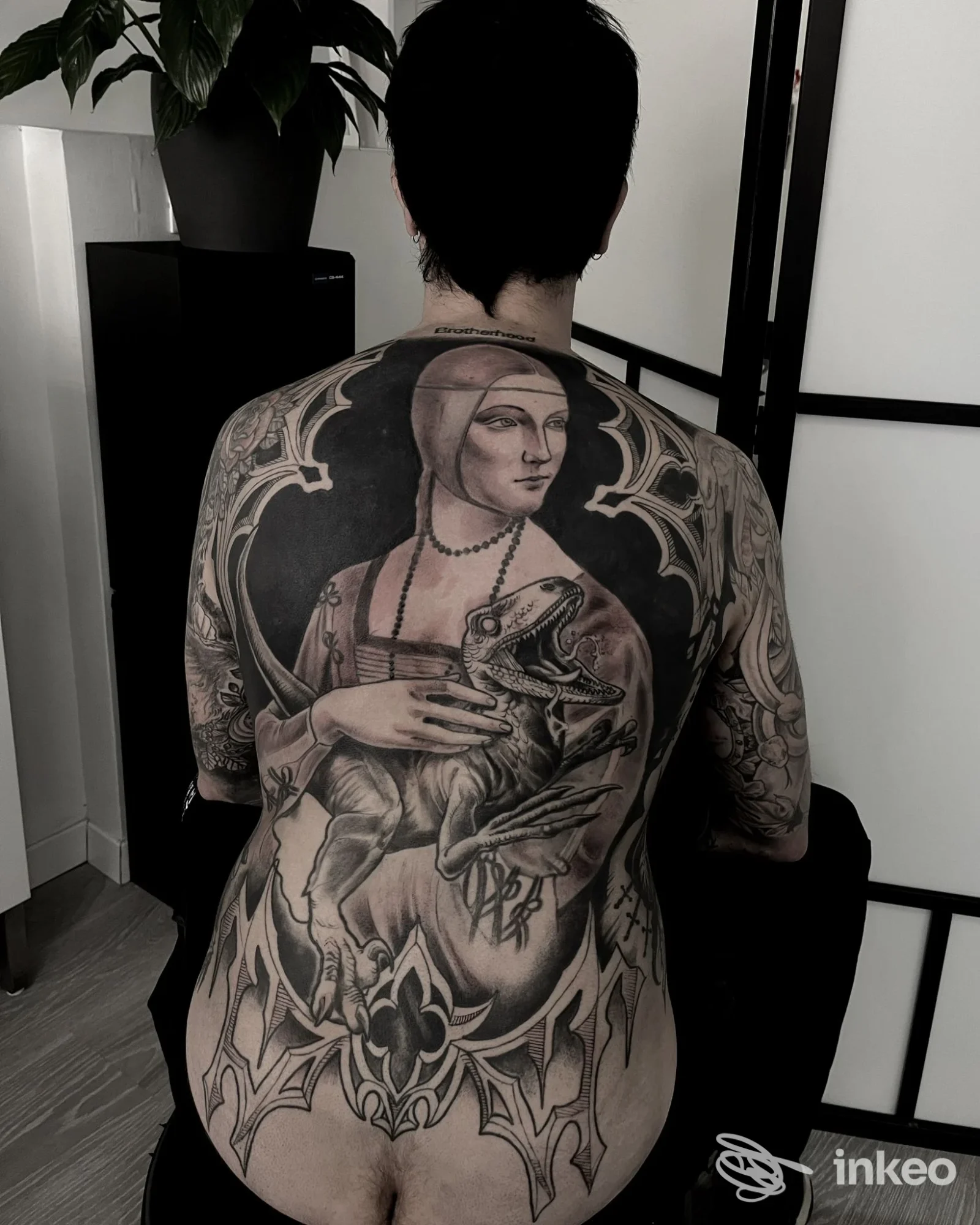 Ampia schiena tatuata con figura femminile rinascimentale e rettile, foto proveniente da ColdStreet a Udine.