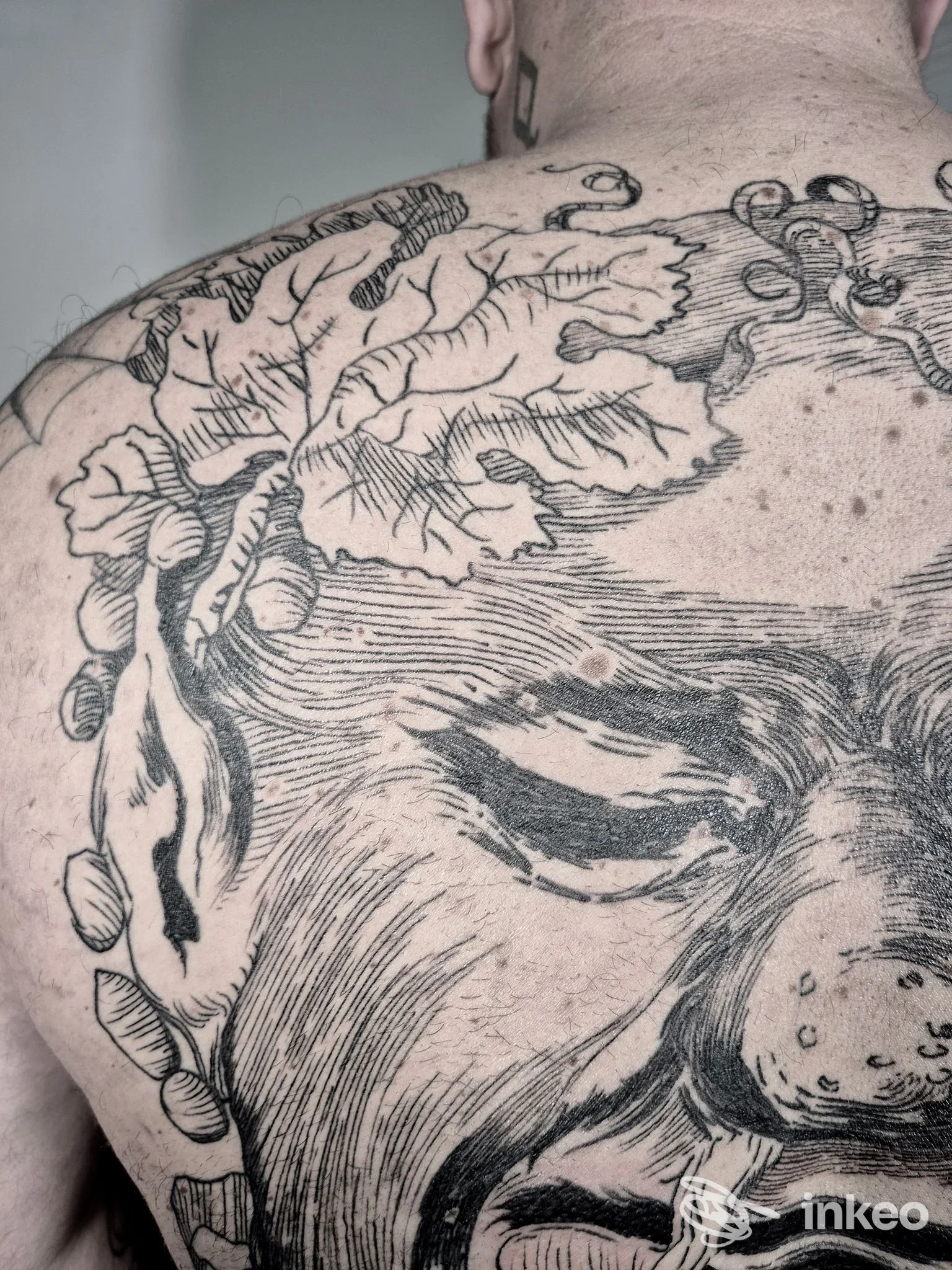 Ampio tatuaggio in bianco e nero sul dorso di una persona, foto fornita da Calla Nera Tattoo Studio, Tricesimo.