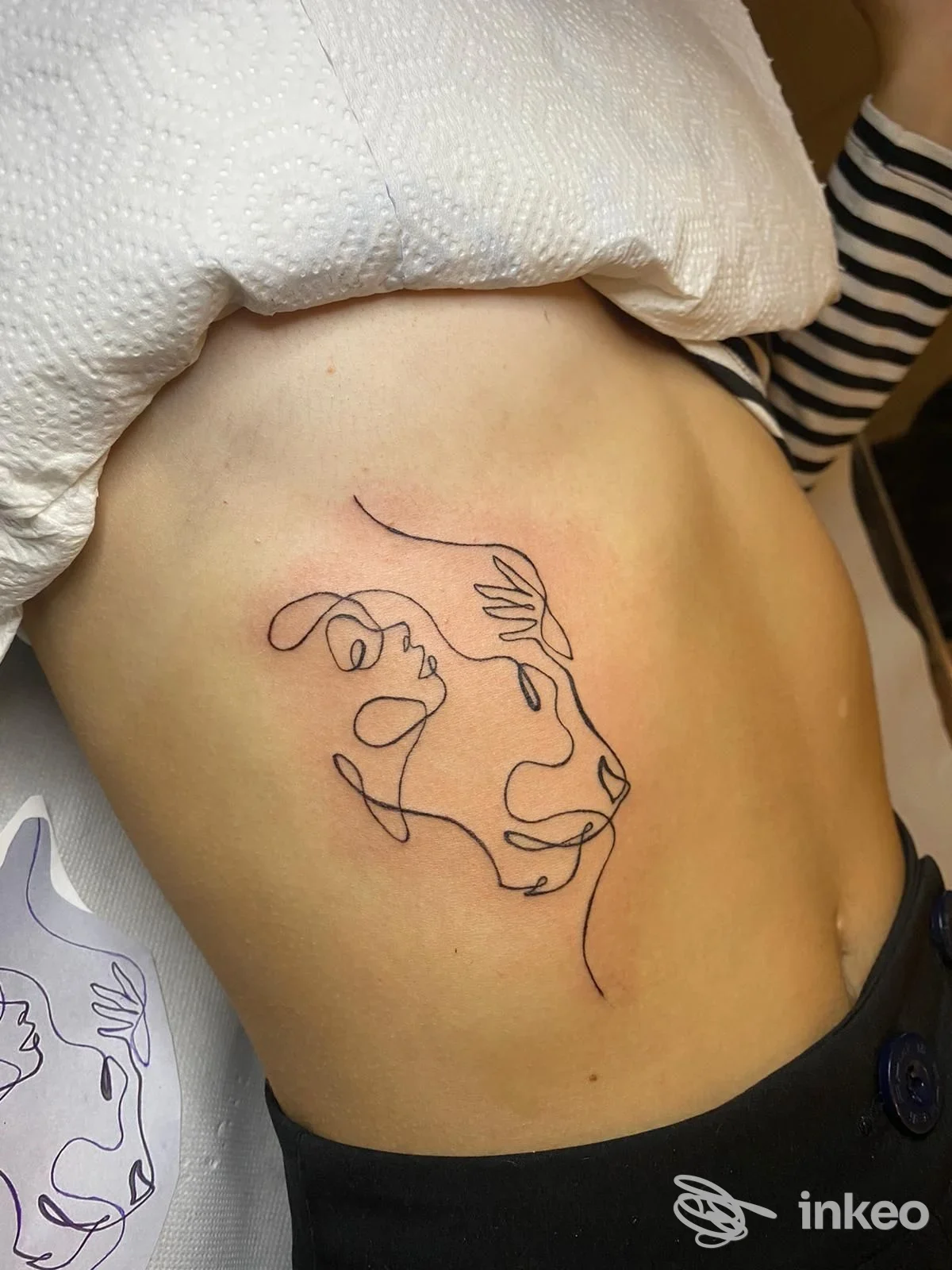 Tatuaggio a linea continua sul fianco, fotografia in primo piano dello stencil e del risultato eseguito da Magia Nera tattoo a Venzone.