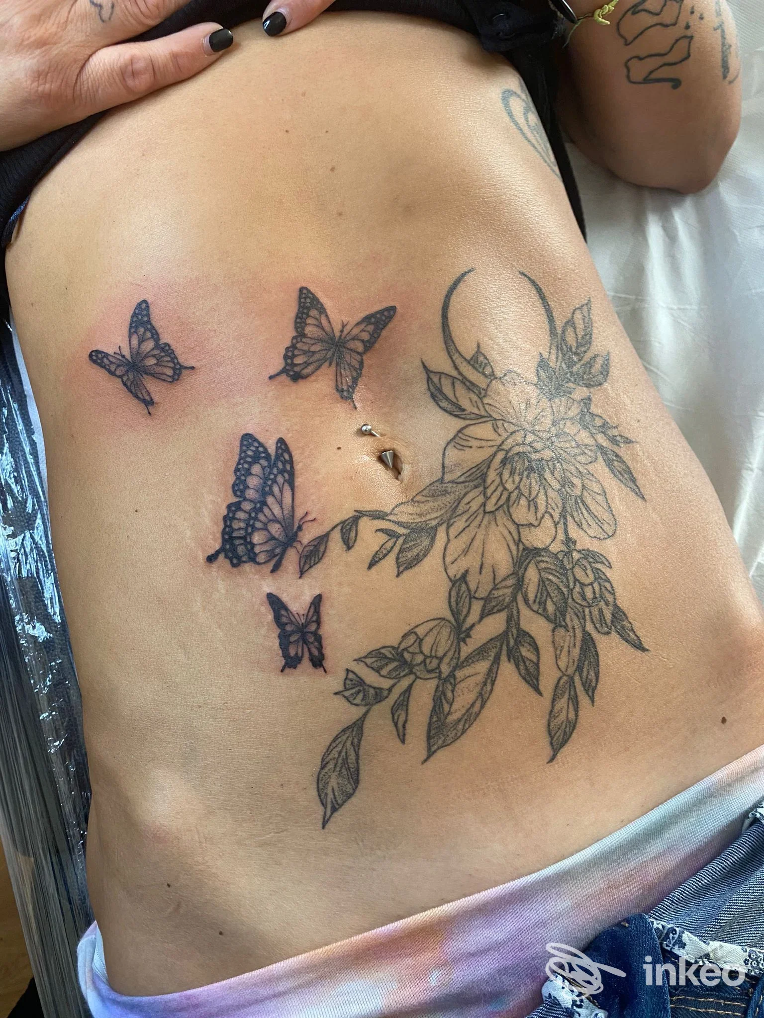 Tatuaggi floreali e farfalle sull'addome, foto inviata dallo studio Magia Nera tattoo a Venzone.