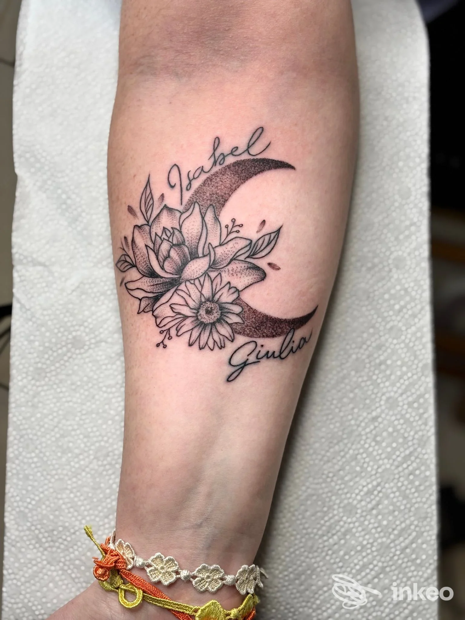 Tatuaggio floreale con mezzaluna sull'avambraccio, realizzato da Strega Ink Tattoo Studio a Villanova.