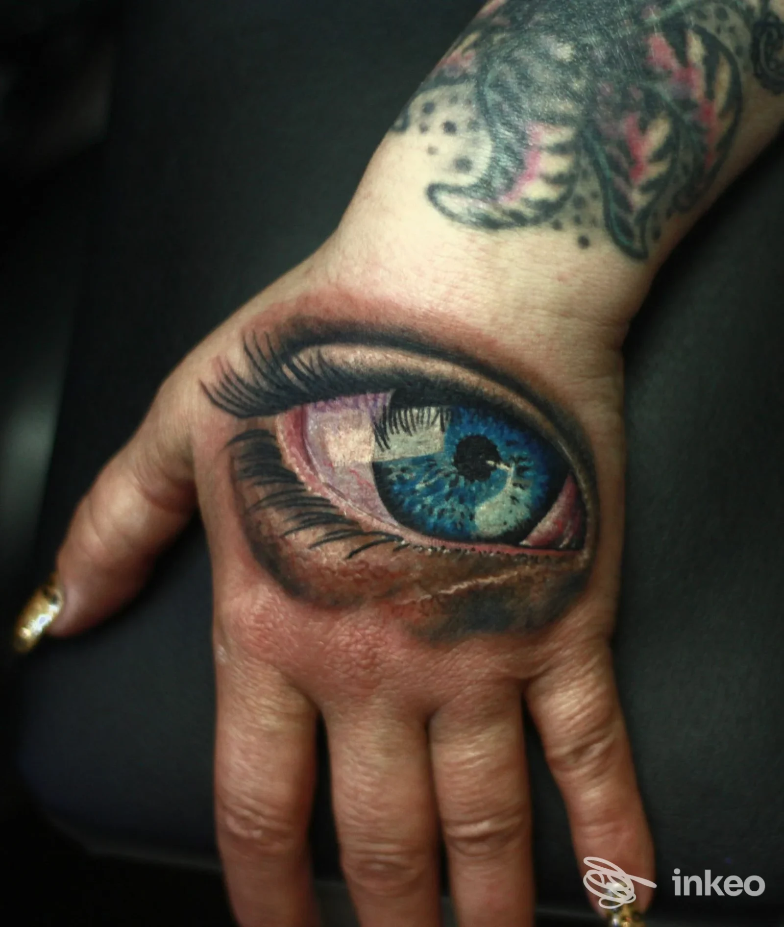 Tatuaggio realistico a forma di occhio sul dorso della mano, foto fornita da Simy Tattoo Studio, Trieste.
