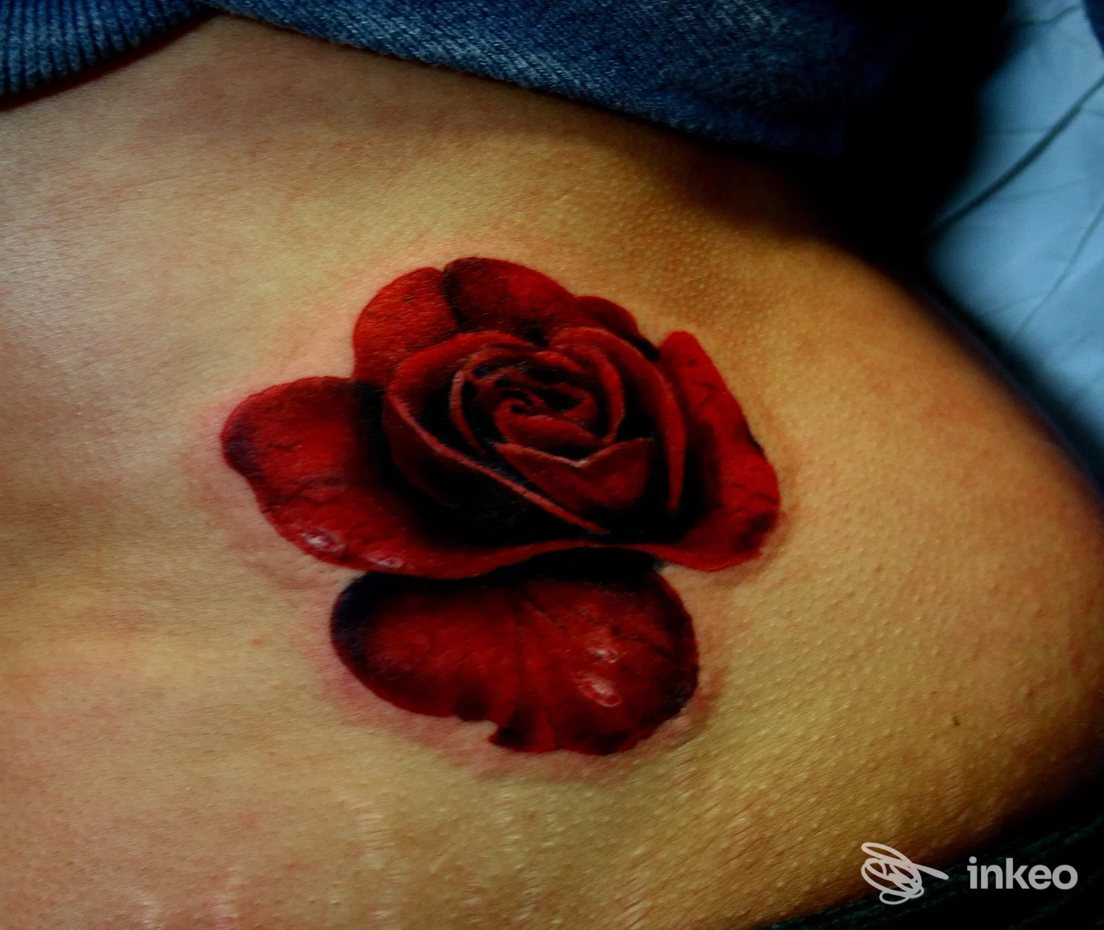 Tatuaggio realistico di una rosa rossa sul fianco, foto di Simy Tattoo Studio a Trieste.