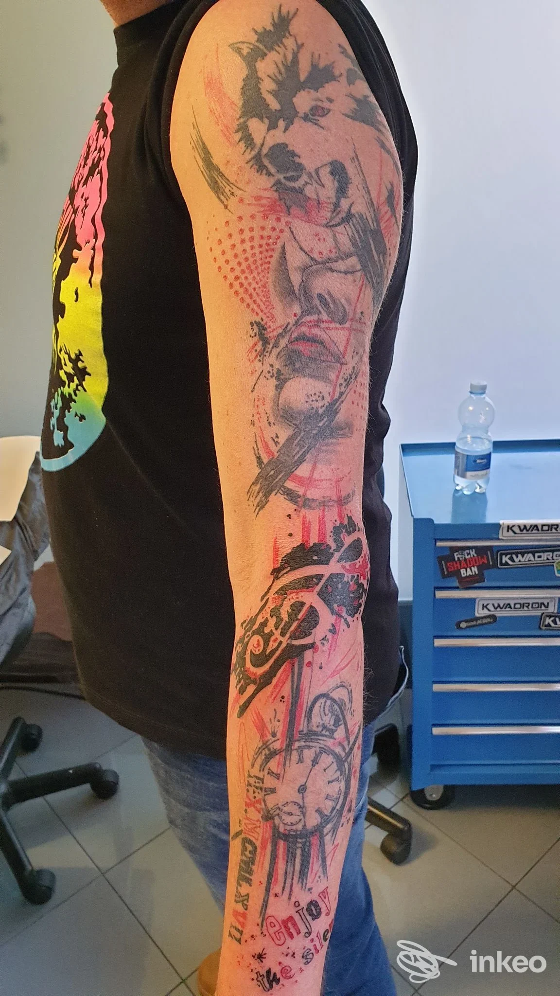 Tatuaggi neri e rossi su avambraccio e bicipite, foto scattata nello studio Tarzan Tattoo Studio a Pagnacco.