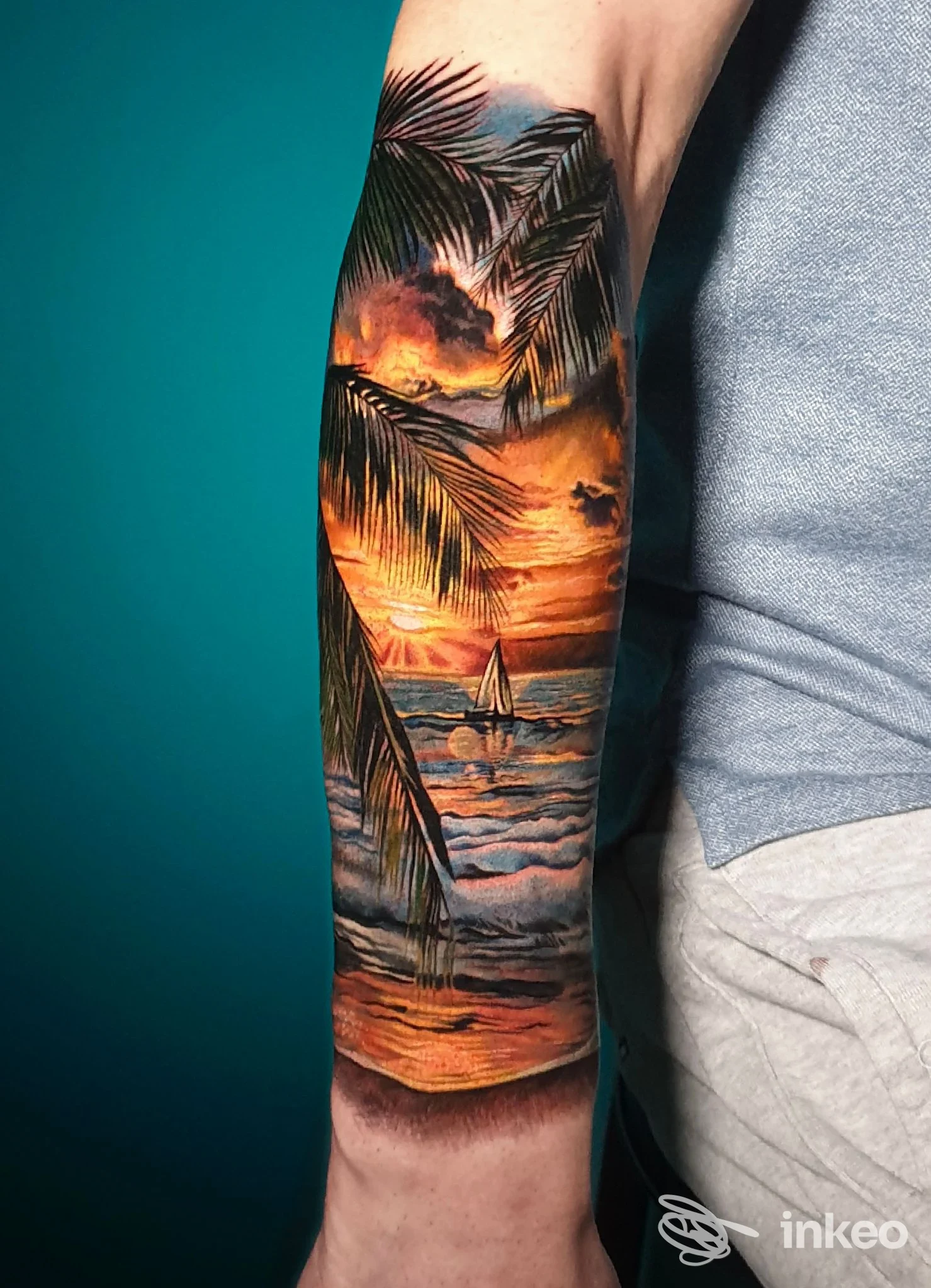Tatuaggio realistico a colori di tramonto tropicale e palme sull'avambraccio, eseguito da Castelli in aria, Gorizia.