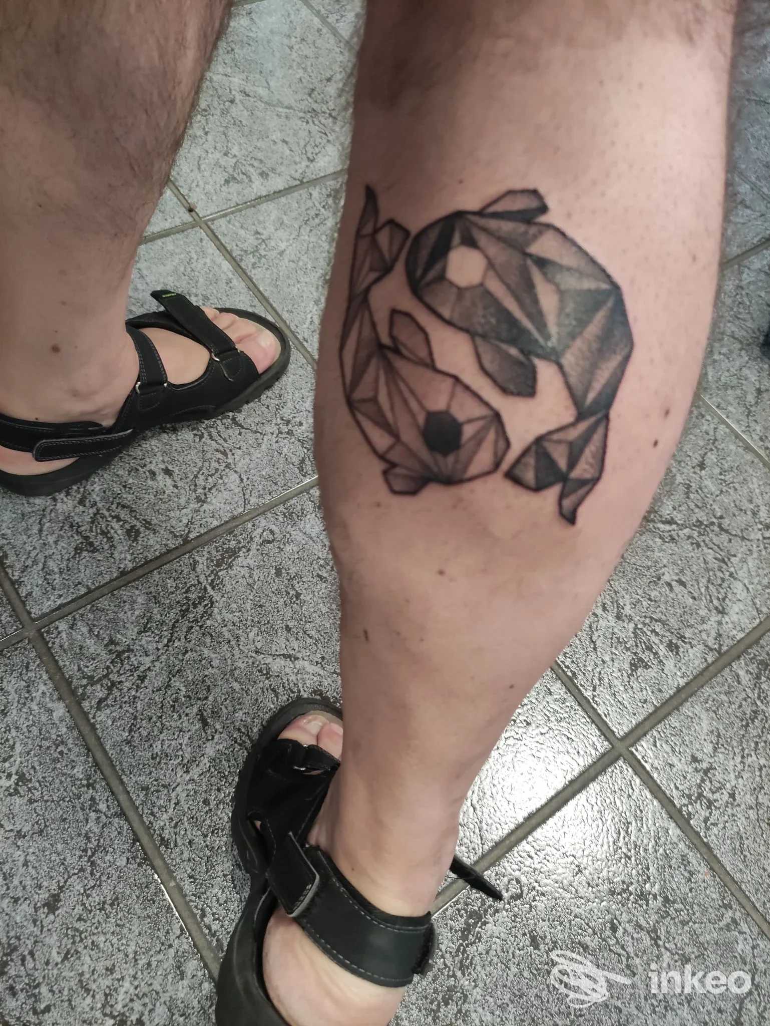 Tattoo geometrico in bianco e nero su gamba, stile origami, visibile su pelle, in una sala tatuaggi italiana, Bollate.