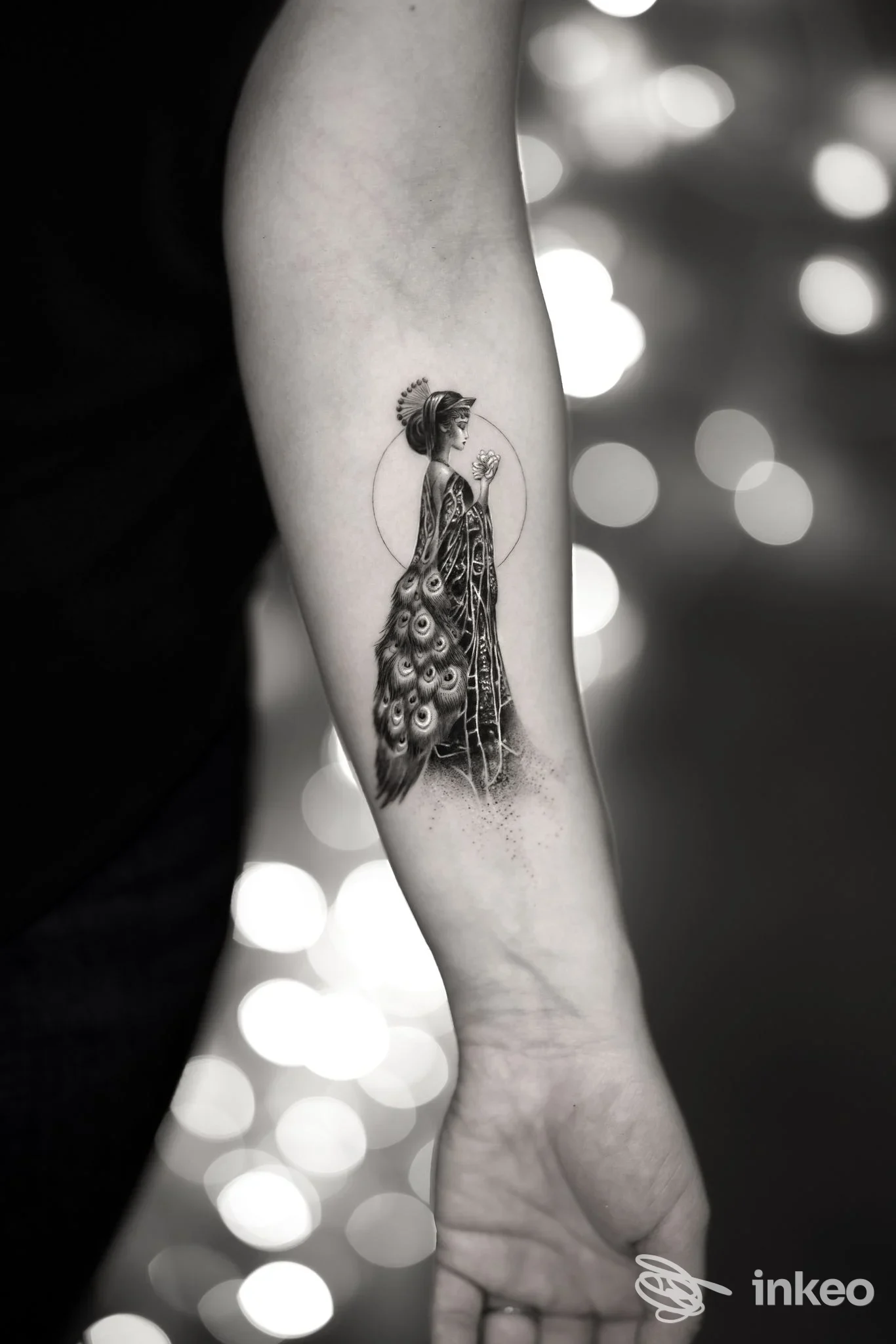 Tatuaggio su avambraccio di figura femminile con piume di pavone, foto inviata da Aureo Roma Tattoo & Gallery, Roma.