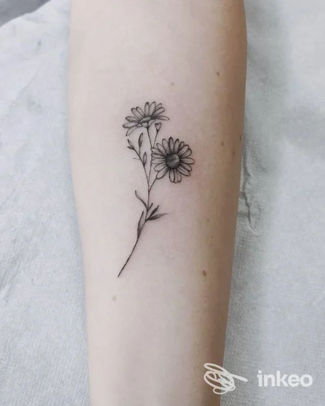 Piccolo tatuaggio a margherita in bianco e nero sull'avambraccio, realizzato da Assosacro Tattoo Shop a Colleferro.