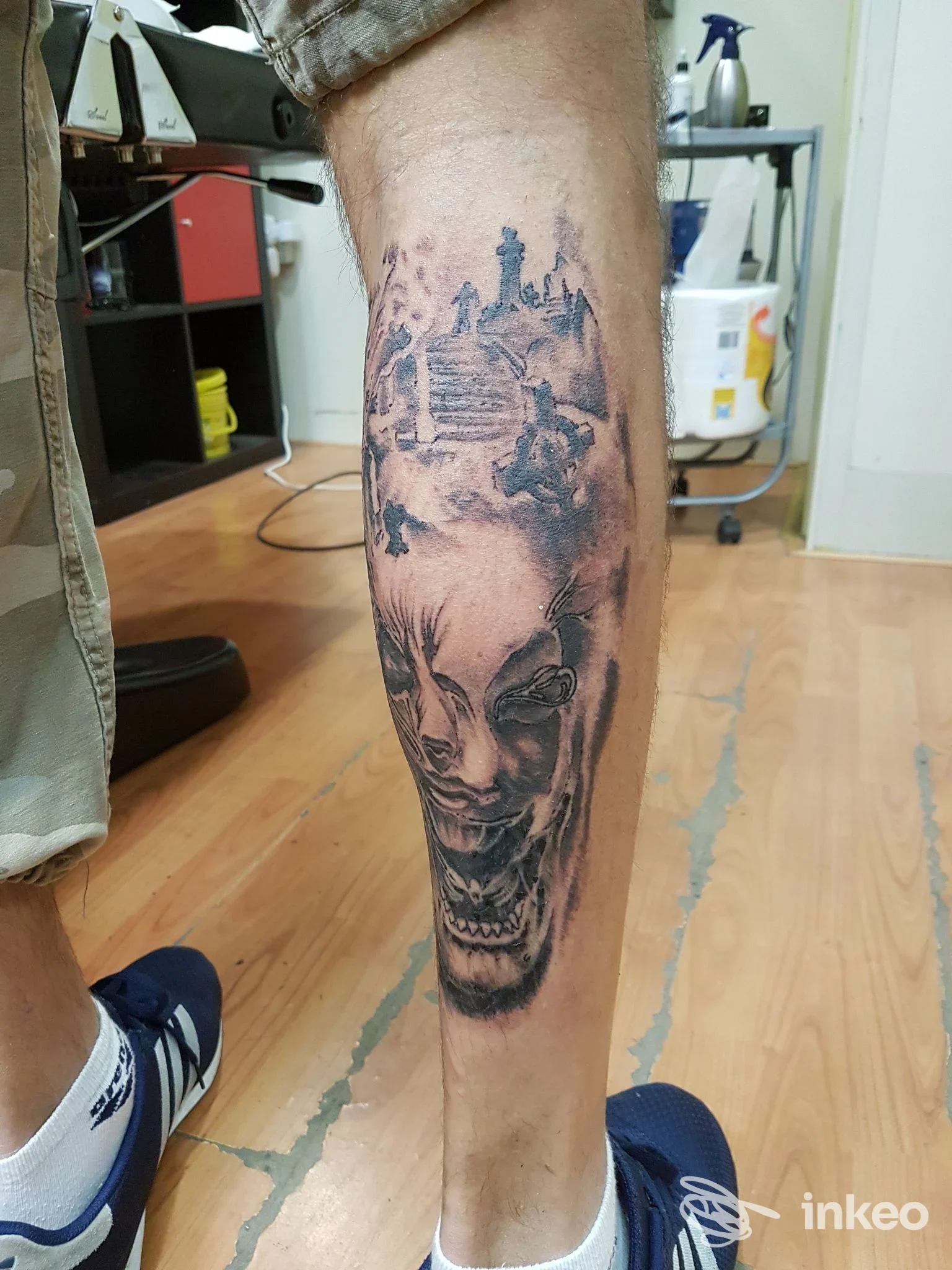Tatuaggio black-and-grey su polpaccio con volti e paesaggio, foto fornita da B.D.Q. Tattoo Studio S.A.S., Roma.