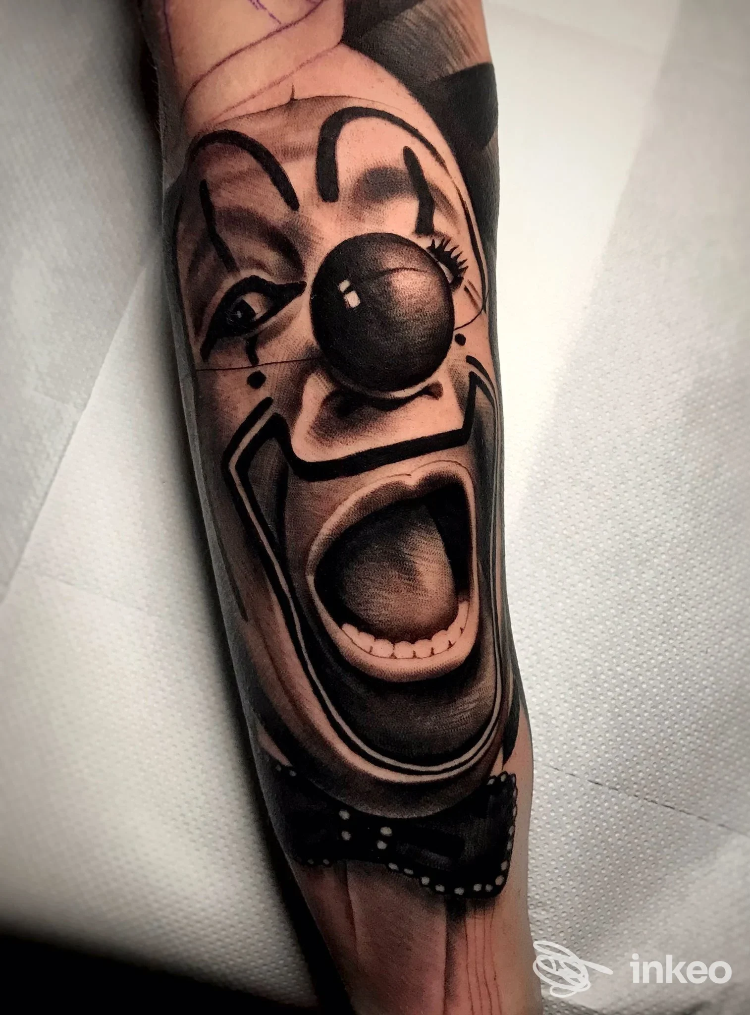 Primo piano di un tatuaggio realistico di clown in bianco e nero sull'avambraccio, foto scattata da Believe in Yourself Tattoo, Roma.