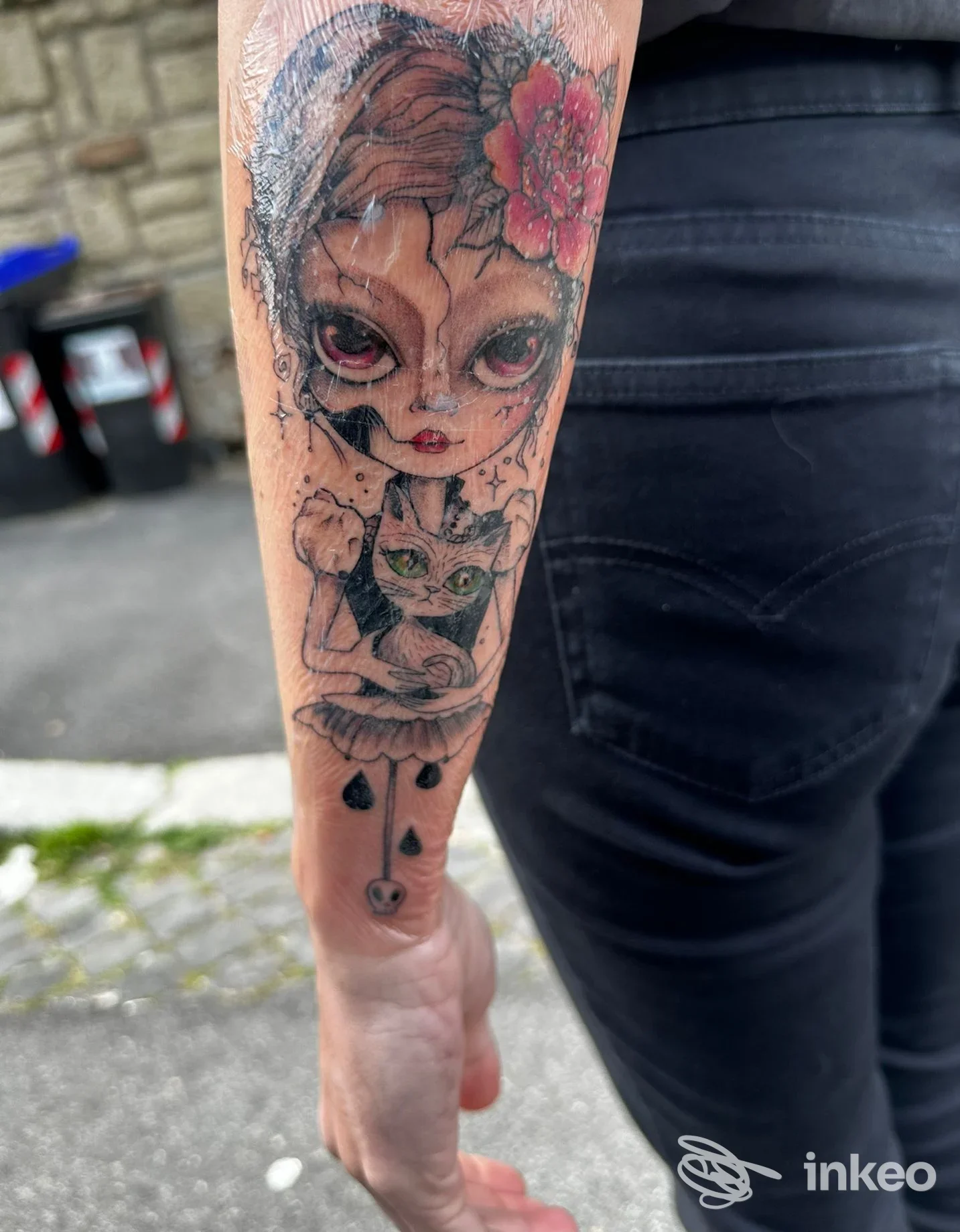 Tatuaggio sull'avambraccio con volto stilizzato e un gatto, foto fornita da Arch Ink Tattoo, Roma.
