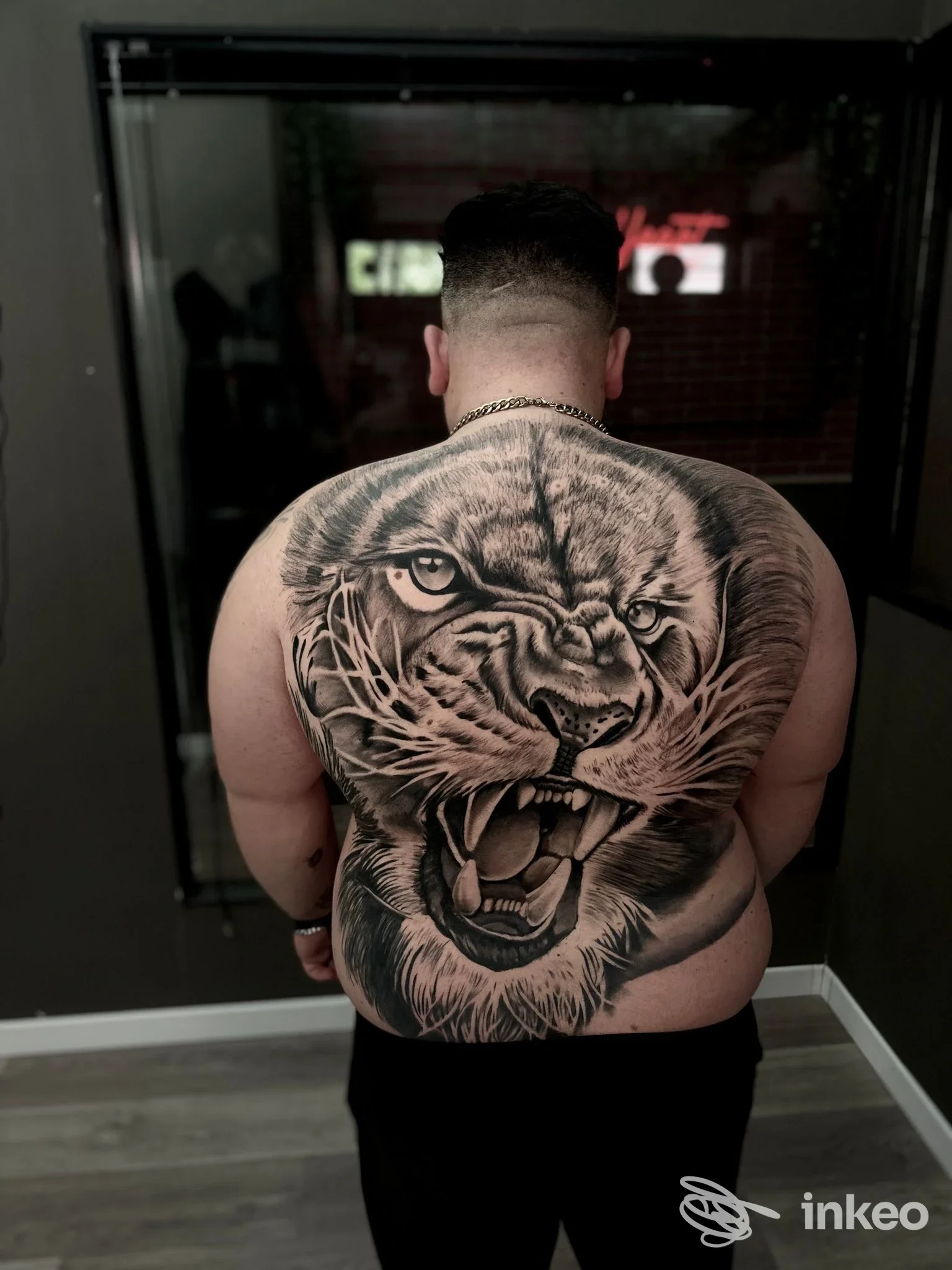 Grande tatuaggio realistico di una testa di tigre sulla schiena di un cliente, Black Heart Tattoo Studio, Cassino.