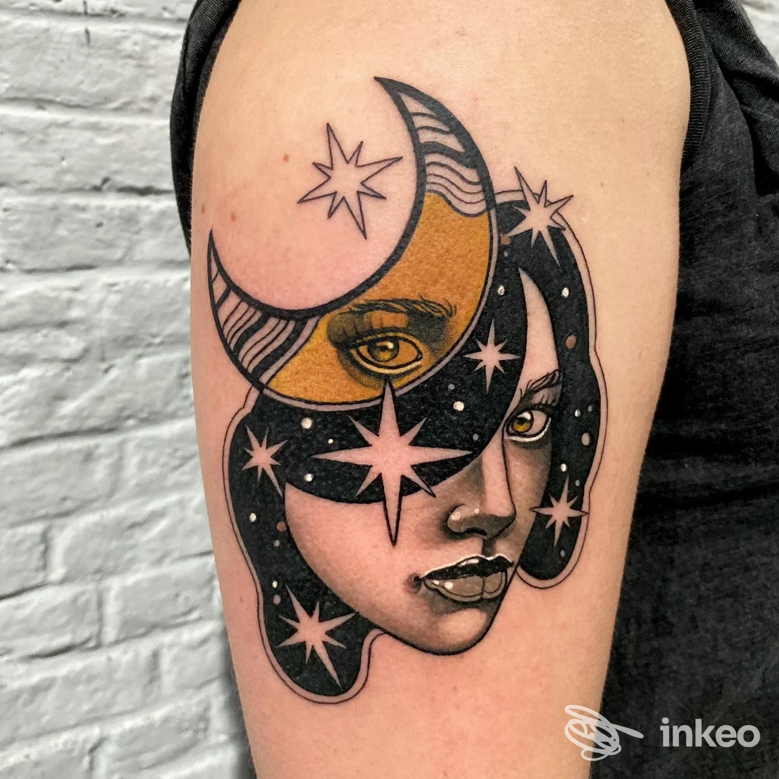 Tatuaggio sul braccio superiore raffigurante volto femminile con luna e stelle, realizzato da Black Shadows Tattoo Studio a Ronciglione.