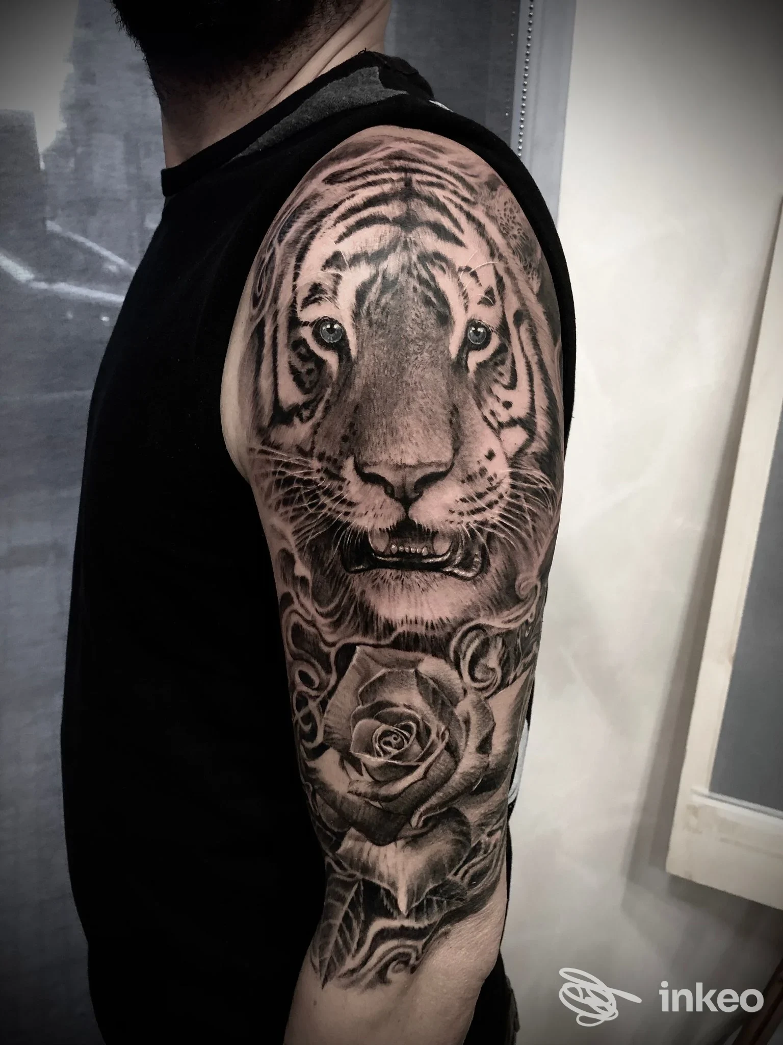 Grande tatuaggio a manica con testa di tigre e rose sul braccio di un uomo, fotografato nello studio Buildink Site Tattoo a Roma.