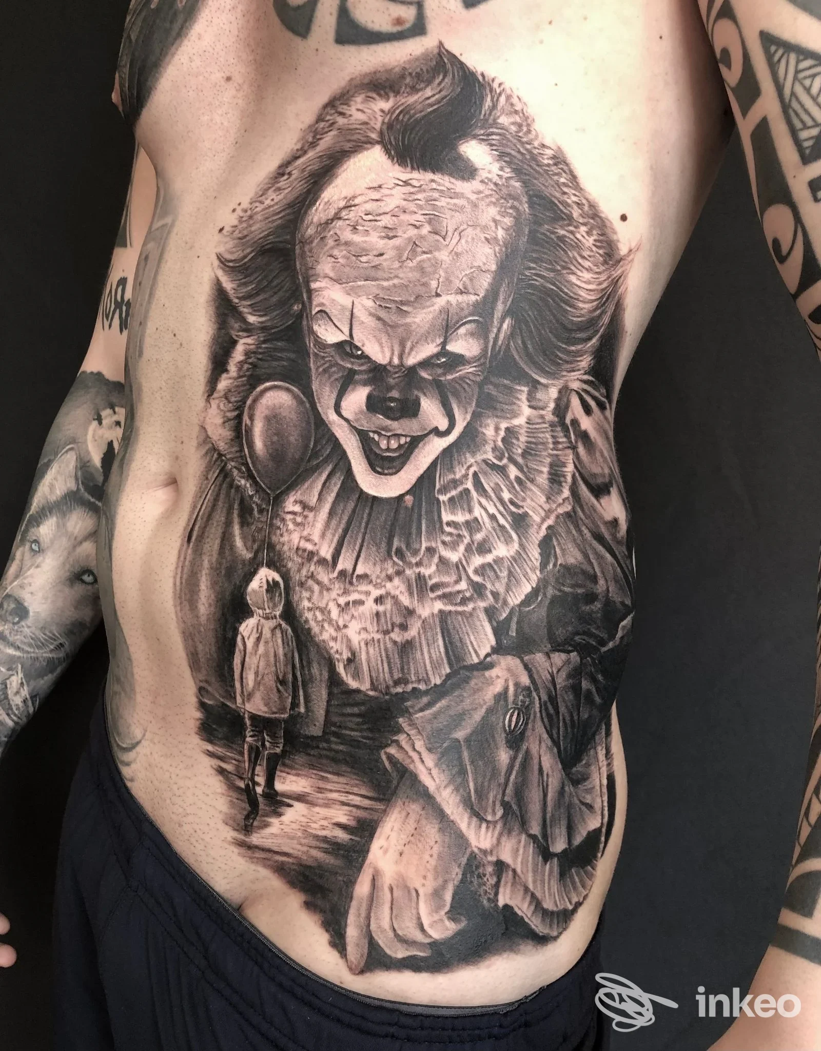 Ampio tatuaggio in bianco e nero raffigurante Pennywise sul fianco e torace, foto fornita da Buildink Site Tattoo, Roma.