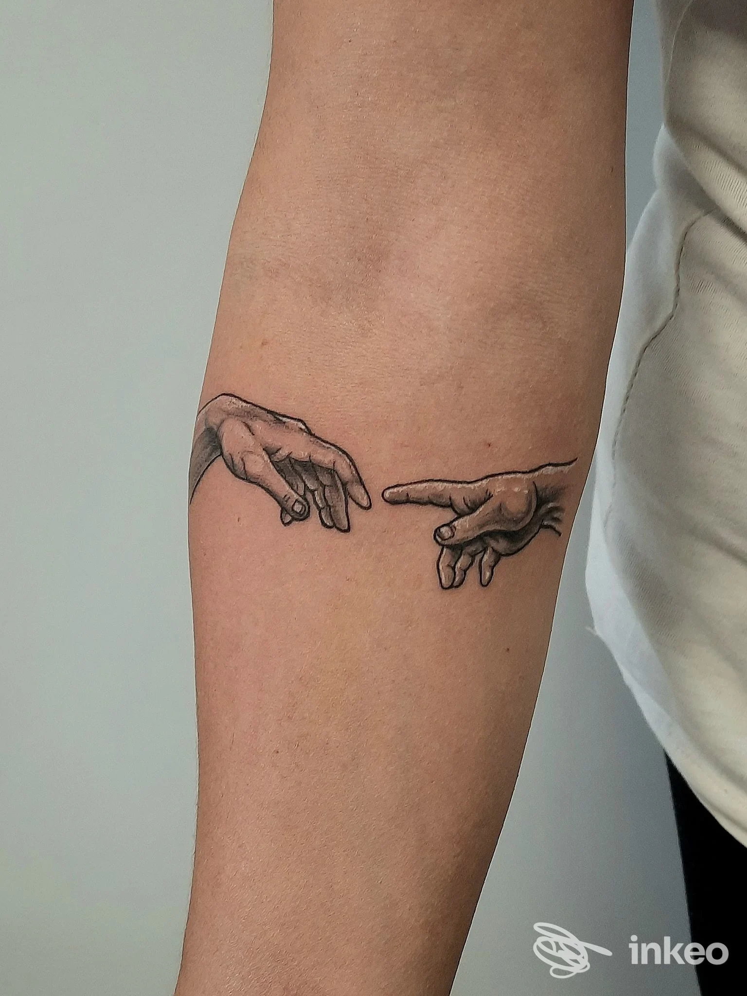 Tatuaggio a inchiostro nero di due mani quasi sovrapposte sull'avambraccio, foto pubblicata da Castle Tattoo - Tatuaggi Roma, Roma.