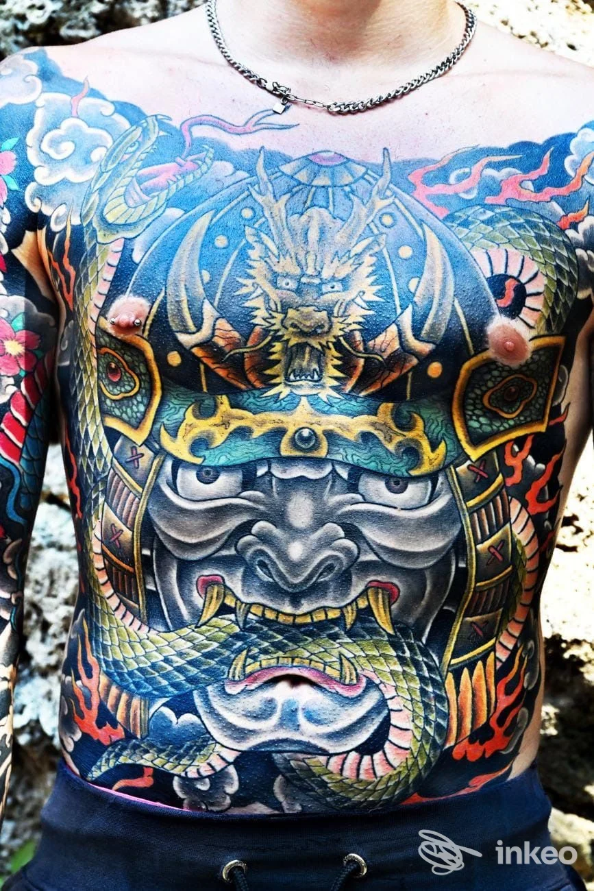 Ampio tatuaggio a tema drago e maschera sul torace, fotografia per DRAGON TATTOO, Roma.
