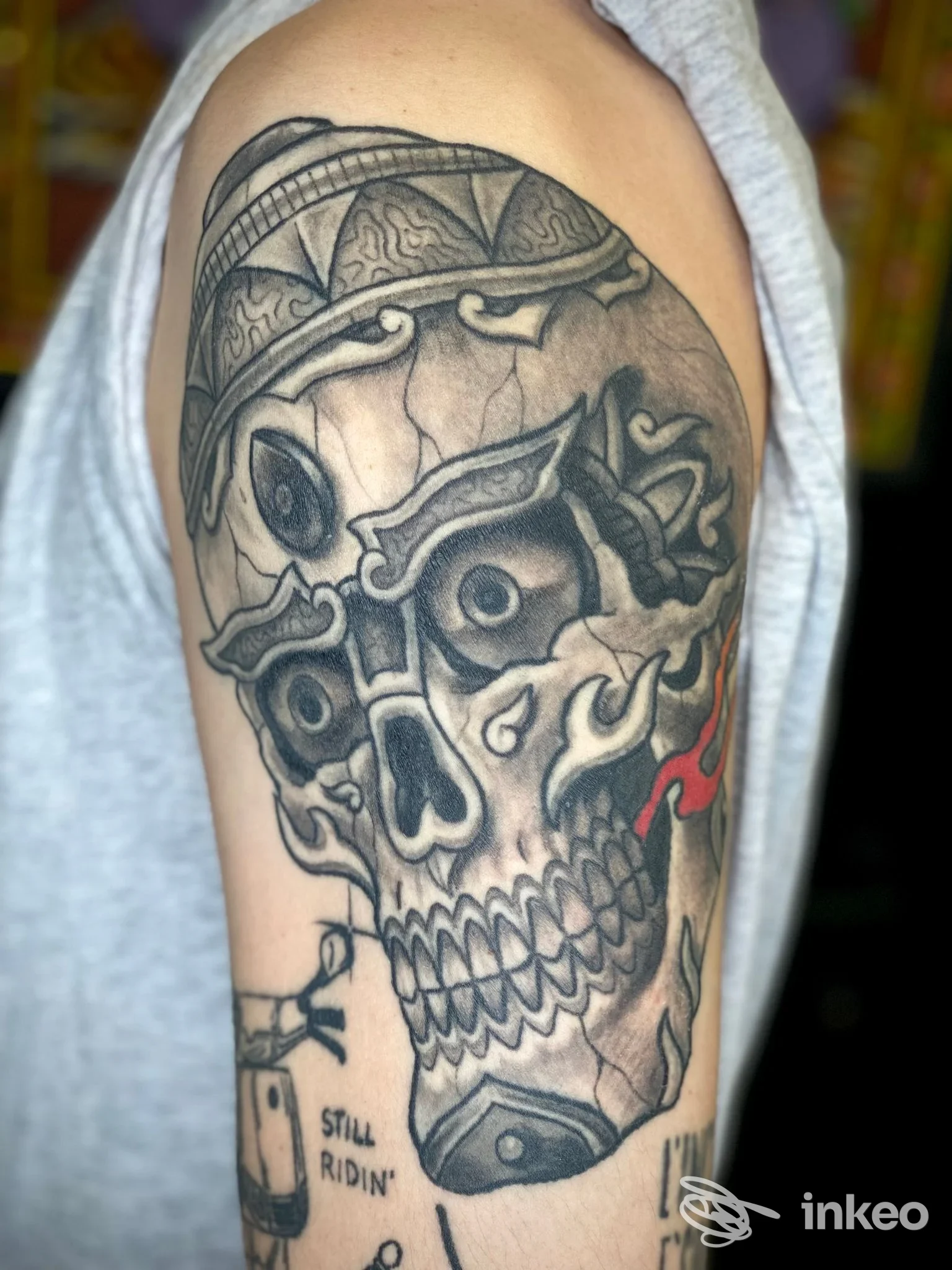 Grande tatuaggio scheletrico in nero e grigio sull'alto braccio, con dettagli rossi; foto fornita da DRAGON TATTOO, Roma.