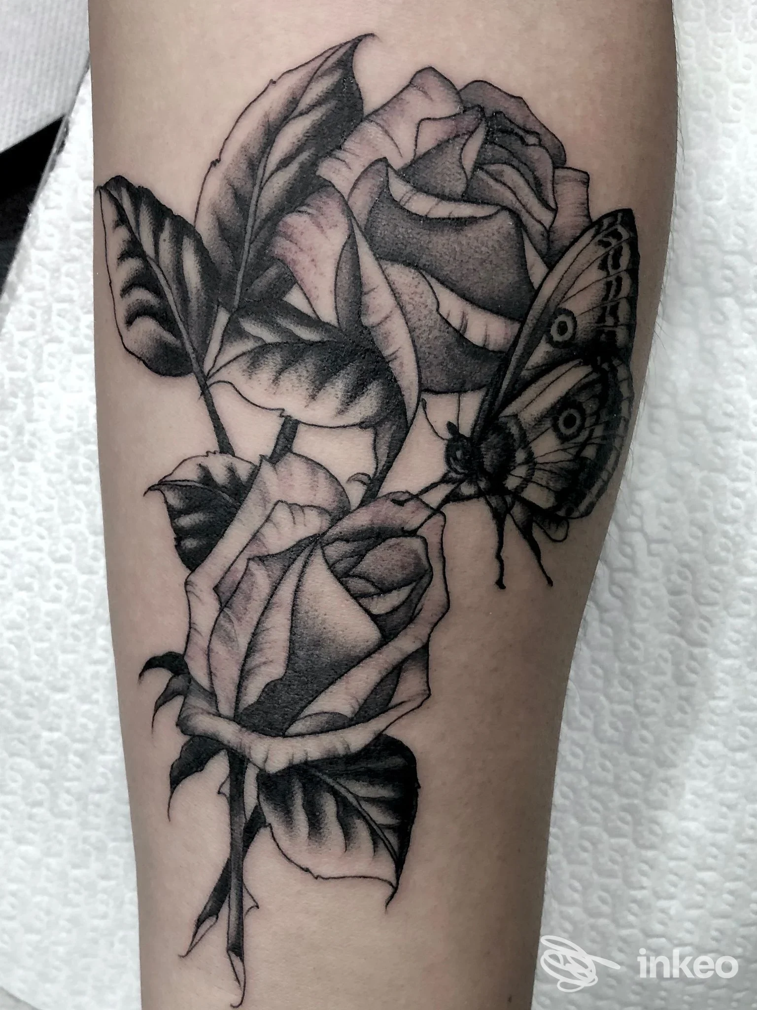 Tatuaggio su avambraccio con due rose e una farfalla, Dear John Tattoo, Velletri.