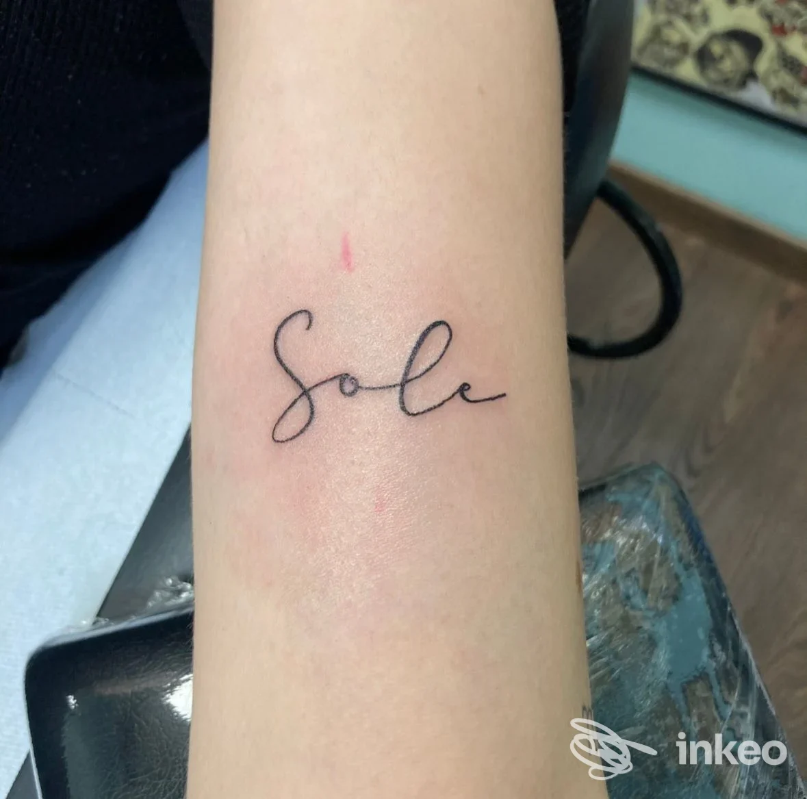 Primo piano di un tatuaggio lettering 'Sole' in inchiostro nero sull'avambraccio, Dolce Vita Tattoo Gallery, Roma.