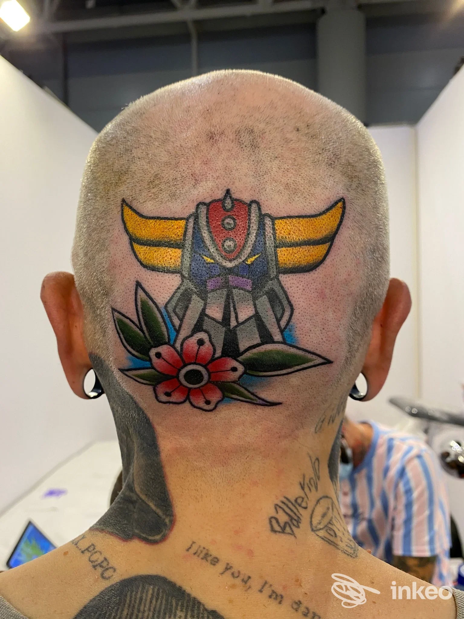 Foto ravvicinata del tatuaggio colorato sulla nuca di una persona, realizzato da Clipper Tattoo Studio a Roma.