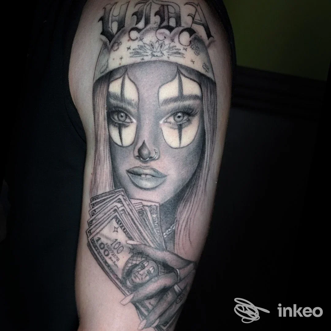 Tatuaggio realistico in bianco e nero di una donna con trucco clown che regge banconote sull'avambraccio, studio Elisabeth Consoli Tattoo Artist a Latina.