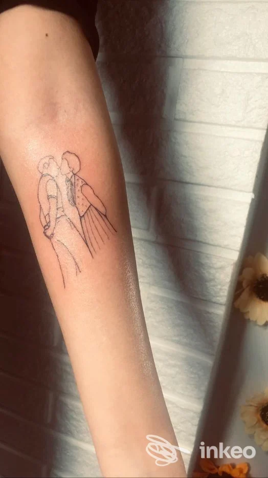 Tatuaggio a linee sottili sull'avambraccio che ritrae due persone che si baciano, realizzato da Enola Tattoo e Piercing a Pontecorvo.