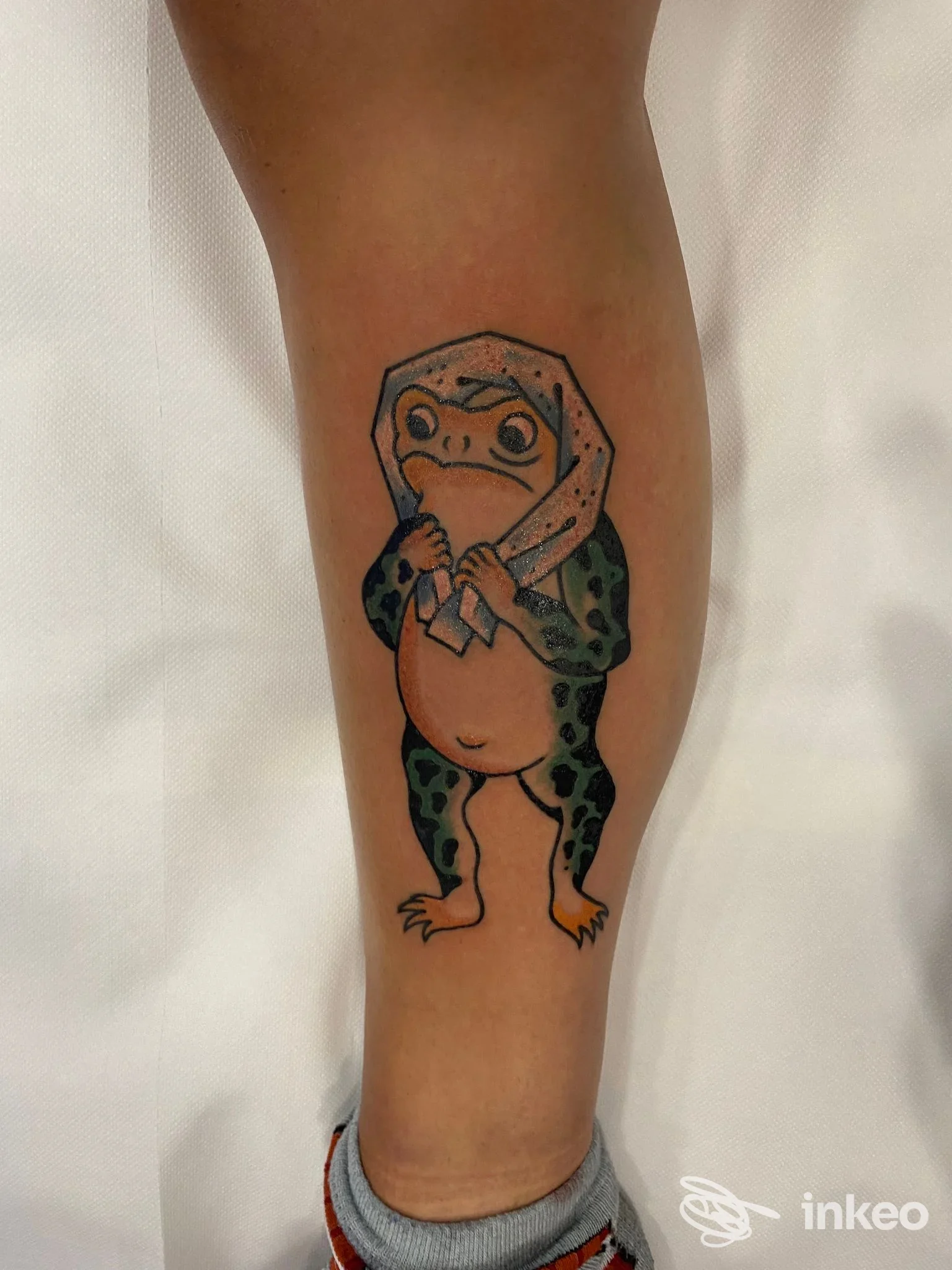 Tatuaggio su polpaccio: rana antropomorfa con fazzoletto, foto fornita da Eternal City Tattoo - Quality Walk in, Roma.