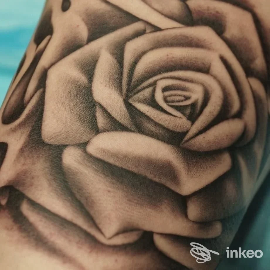 Primo piano di un tatuaggio a rosa in black and grey su pelle, realizzato da Free Hand Tattoo di Simone Scarcioni a Roma.