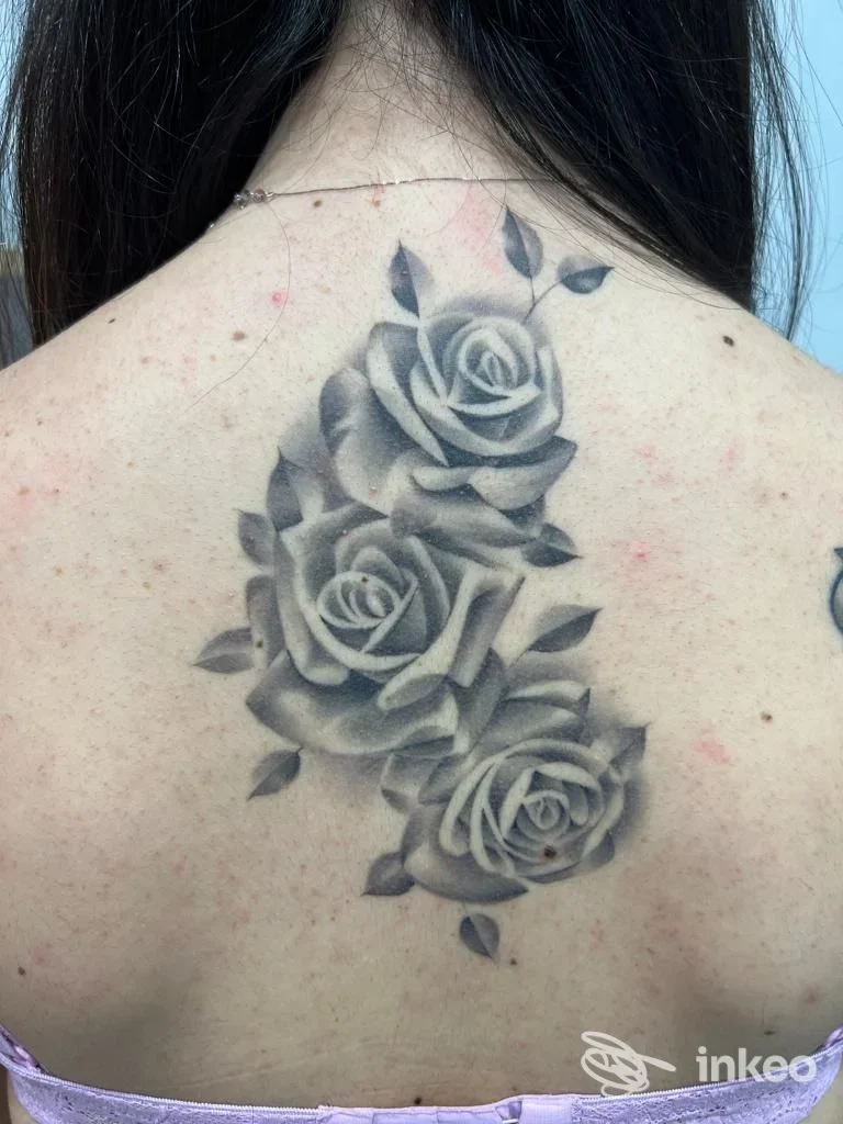 Tre rose in bianco e nero tatuate nella parte superiore della schiena, foto fornita da Free Hand Tattoo di Simone Scarcioni, Roma.
