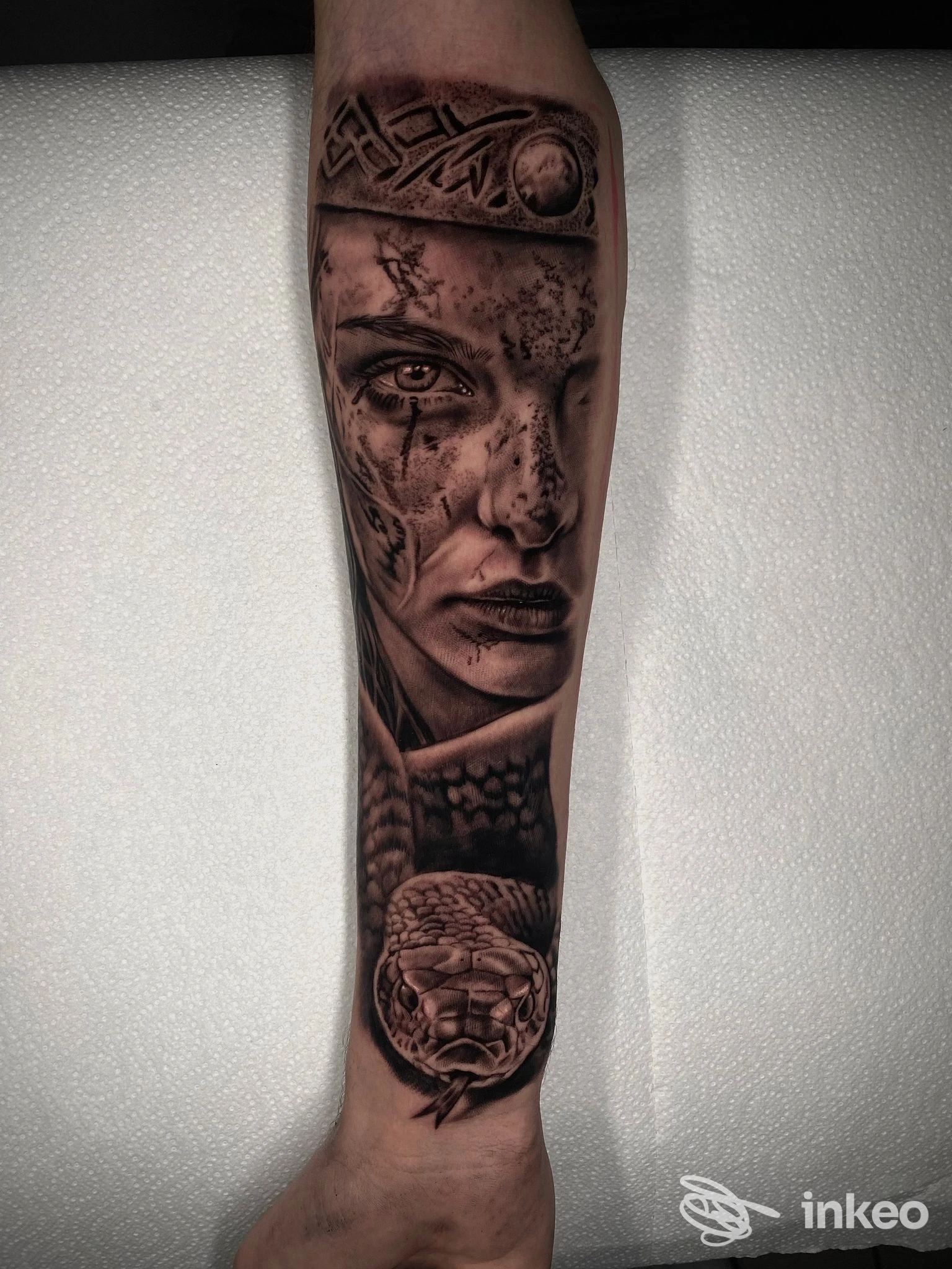 Tattoo realistico sul braccio raffigurante un volto femminile, con dettagli grafici e texture, realizzato sulla pelle.”
