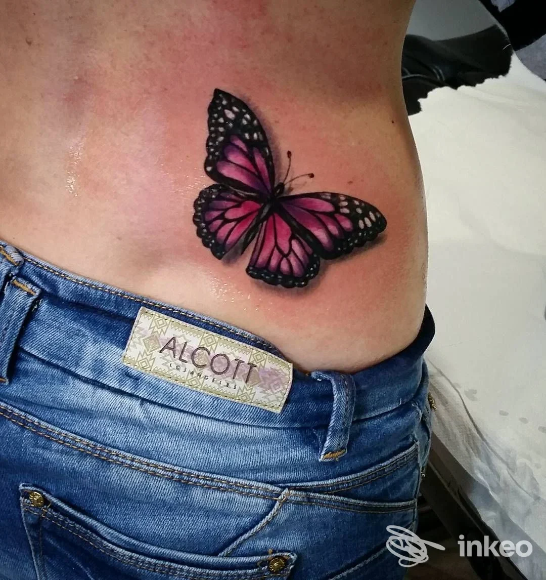 Tatuaggio farfalla rosa-viola sul fianco eseguito da Flavio Atzeni Tattoo, Roma.
