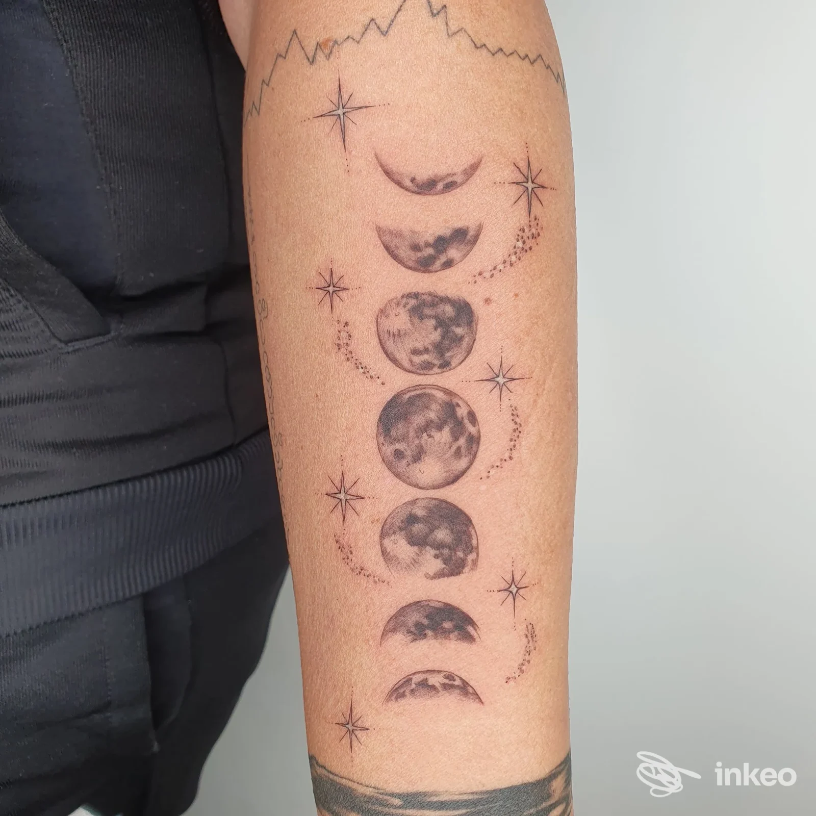 Avambraccio tatuato con una sequenza di fasi lunari in bianco e nero, scatto realizzato per Francisco Tattoo Studio a Monte Porzio Catone.