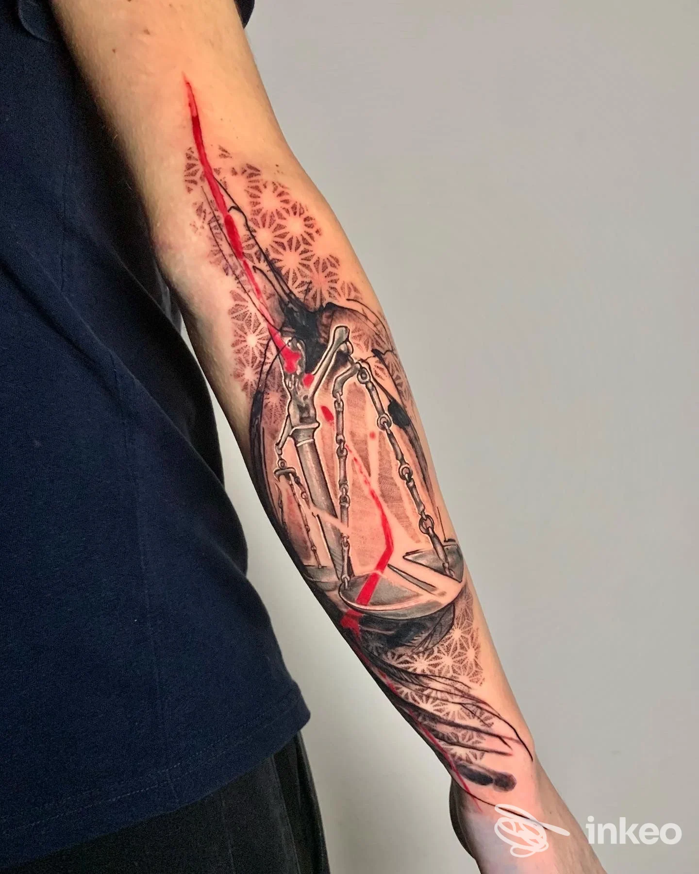 Tatuaggio su avambraccio con elementi scheletrici e accenti rossi, foto condivisa da Greyhounds tattoo, Roma.