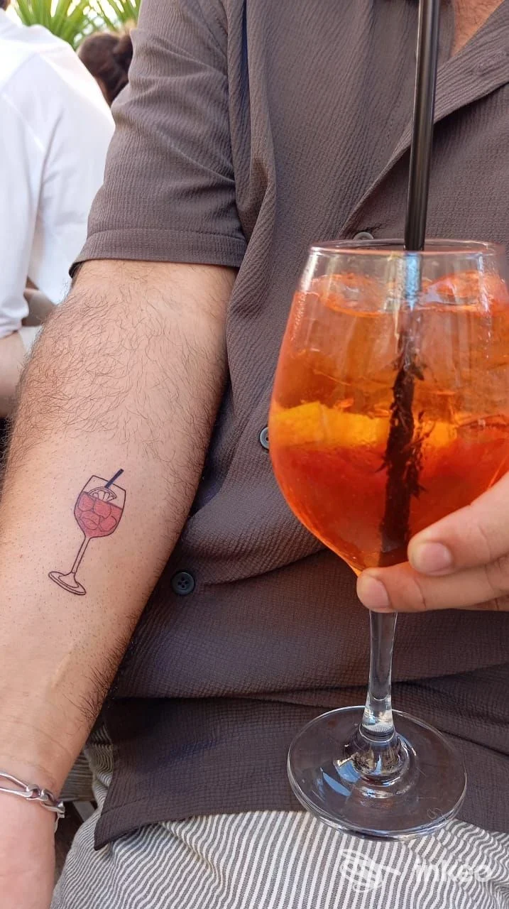 Primo piano sull'avambraccio con tatuaggio a bicchiere di cocktail, foto fornita da Hera Tattoo Studio, Roma.