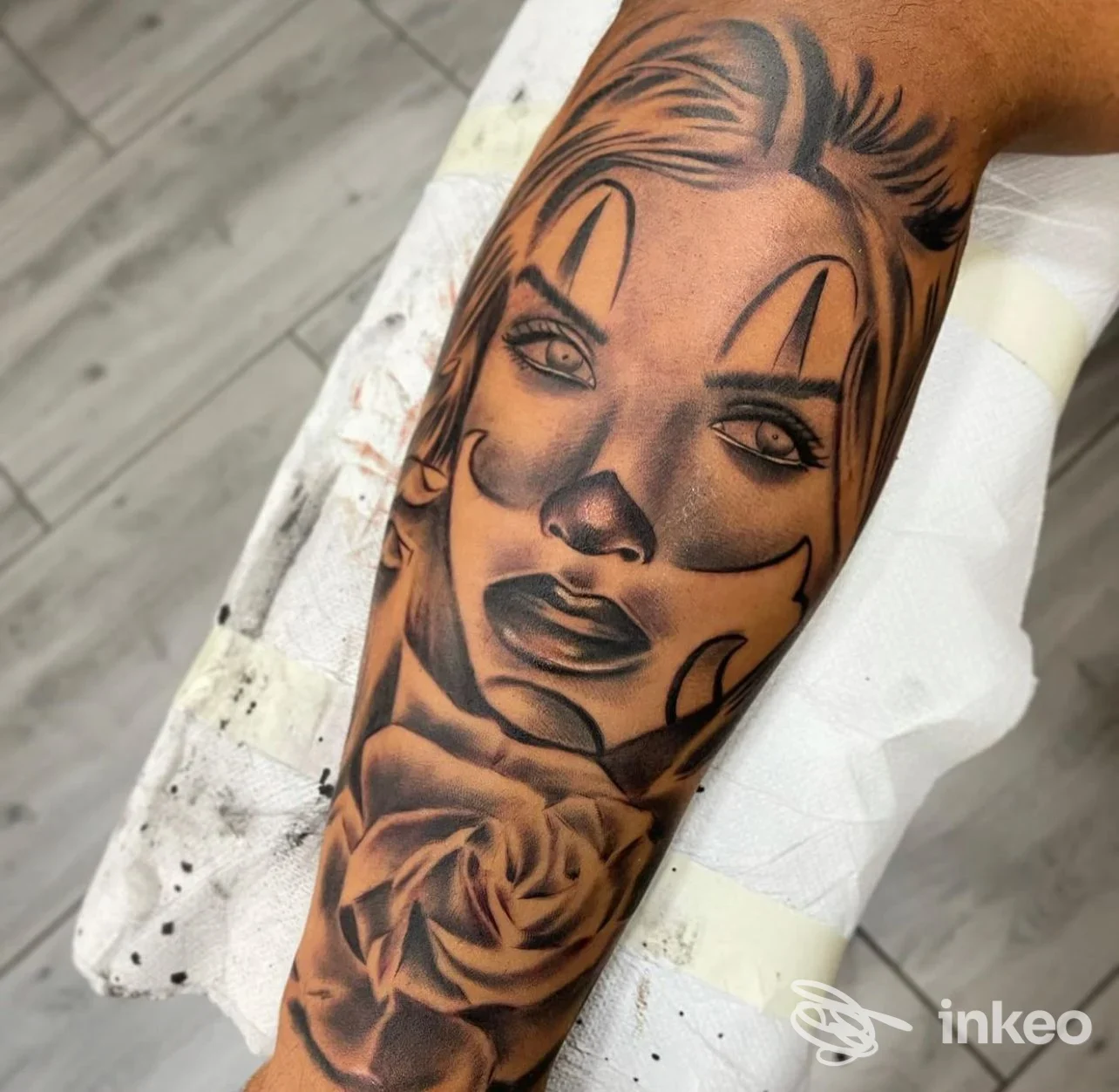 Tatuaggio realistico di volto di donna clown con una grande rosa sull'avambraccio, K-TATTOO, Roma.