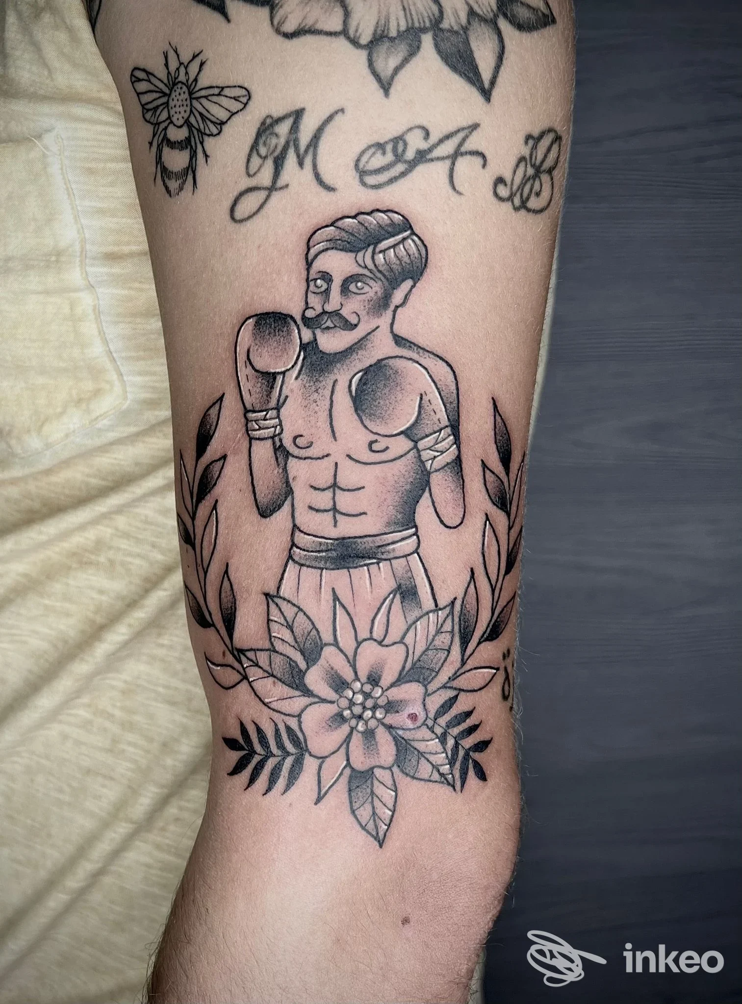 Tatuaggio su avambraccio di un pugile stilizzato, con decorazioni floreali. Healthy Mind Tattoo, Piedimonte San Germano.